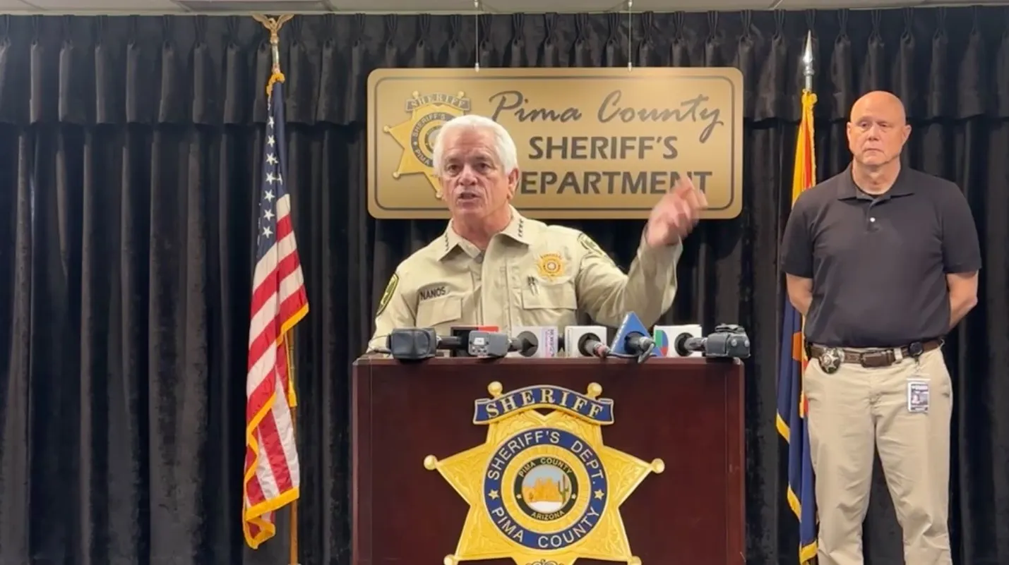 Sheriff Chris Nanos speaking at a news conference, with a colleague standing beside him.