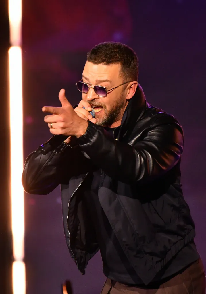 Justin Timberlake performing onstage, holding a microphone.
