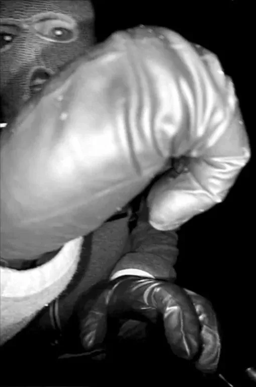 Black and white image of a masked suspect wearing gloves.