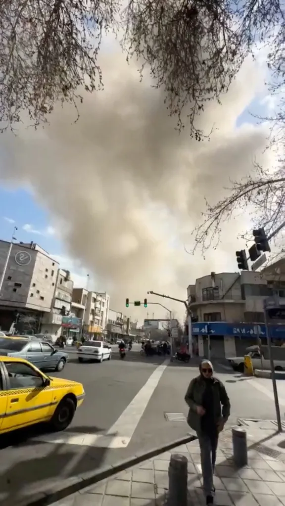 Smoke rising over a Tehran street after an explosion.