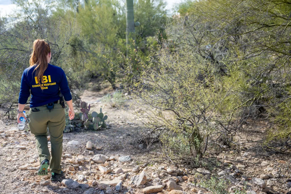 A member of the FBI Evidence Response Team walks through the desert.