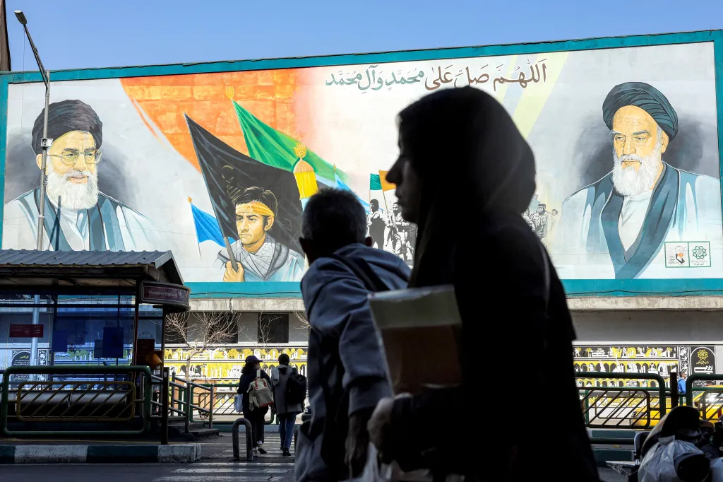 A woman walks near a banner depicting Iran's late and current supreme leaders (R to L) Ayatollah Ruhollah Khomeini and Ayatollah Ali Khamenei along a main street in Tehran on Feb. 21, 2026. 