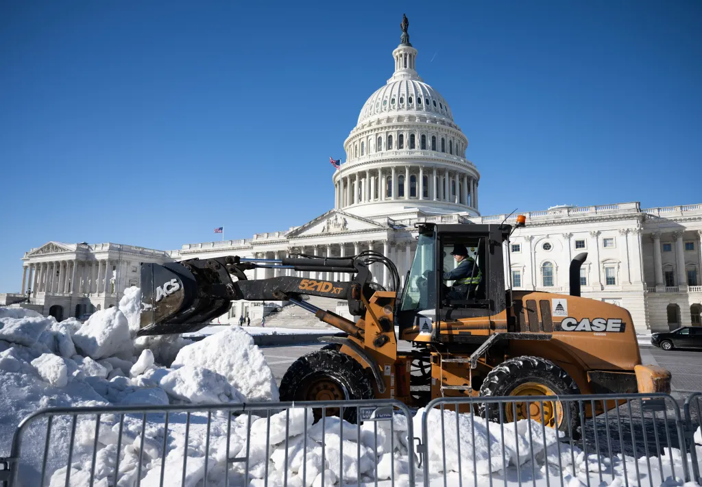 A worker clearing snow outside the US Capitol building.