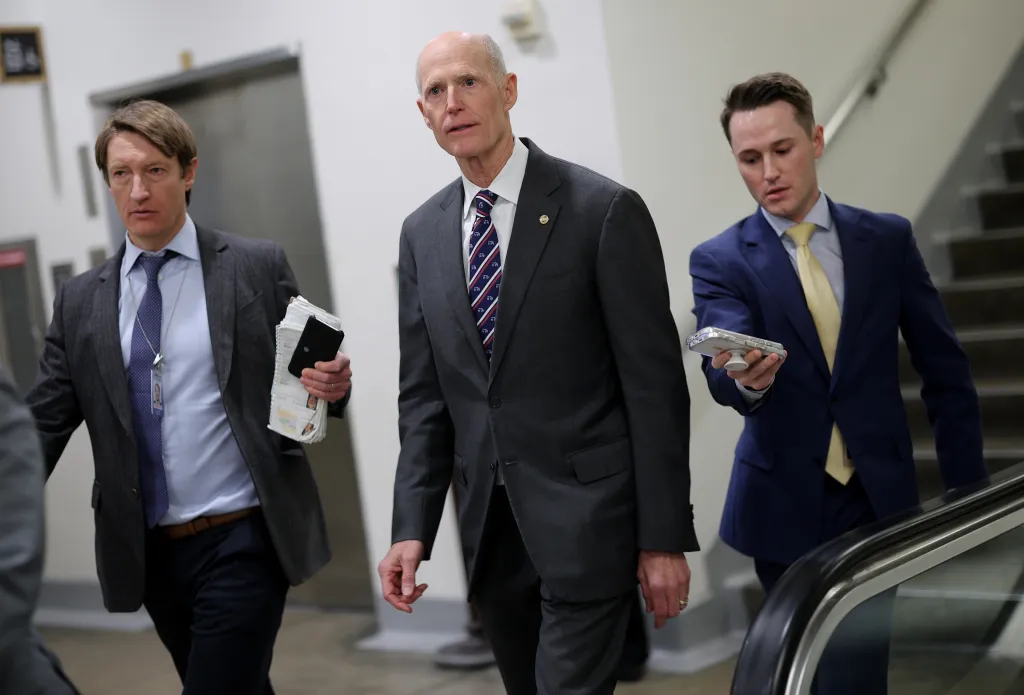 U.S. Sen. Rick Scott (R-FL) walking with two aides to the Senate Chamber.
