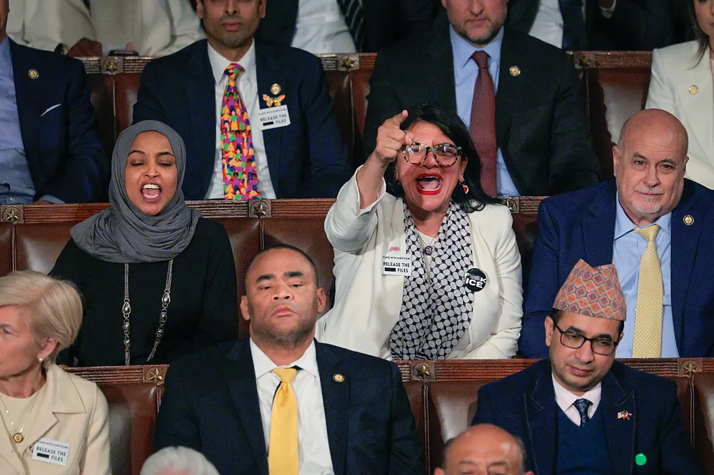 Rep. Rashida Tlaib points and shouts during the State of the Union address, with Rep. Ilhan Omar also shouting beside her, and other attendees wearing