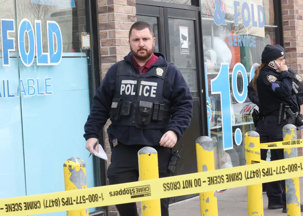 NYPD officers at the scene of a shooting outside a laundromat in Queens.