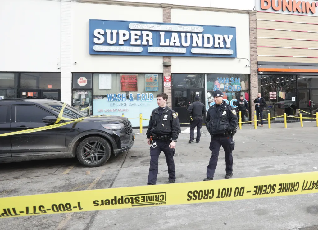 Police investigate a shooting outside a Super Laundry and Dunkin' in Queens, NY.