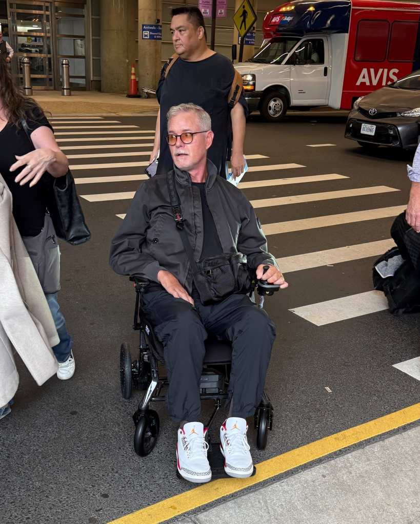 Eric Dane in a wheelchair at an airport.