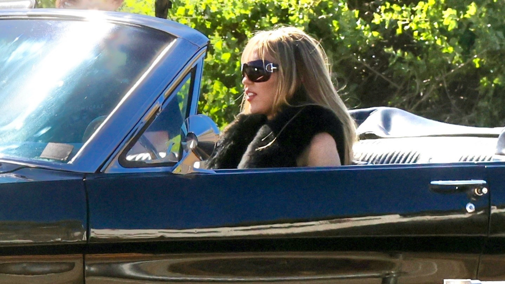 Miley Cyrus as Hannah Montana, in a convertible.