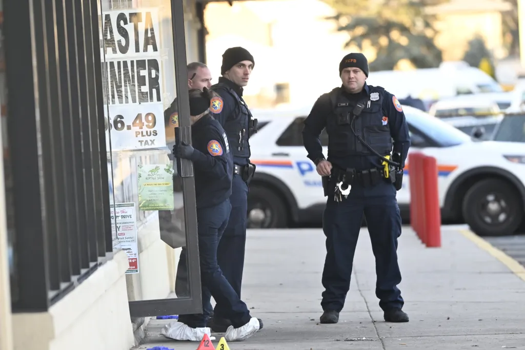 Police officers investigating a fatal stabbing at A & A Italian Deli in Bethpage, Long Island.