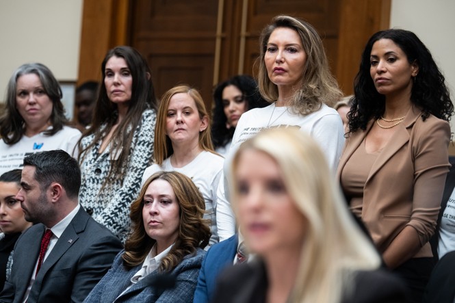Victims stand behind Bondi, who faces forward and does not turn around