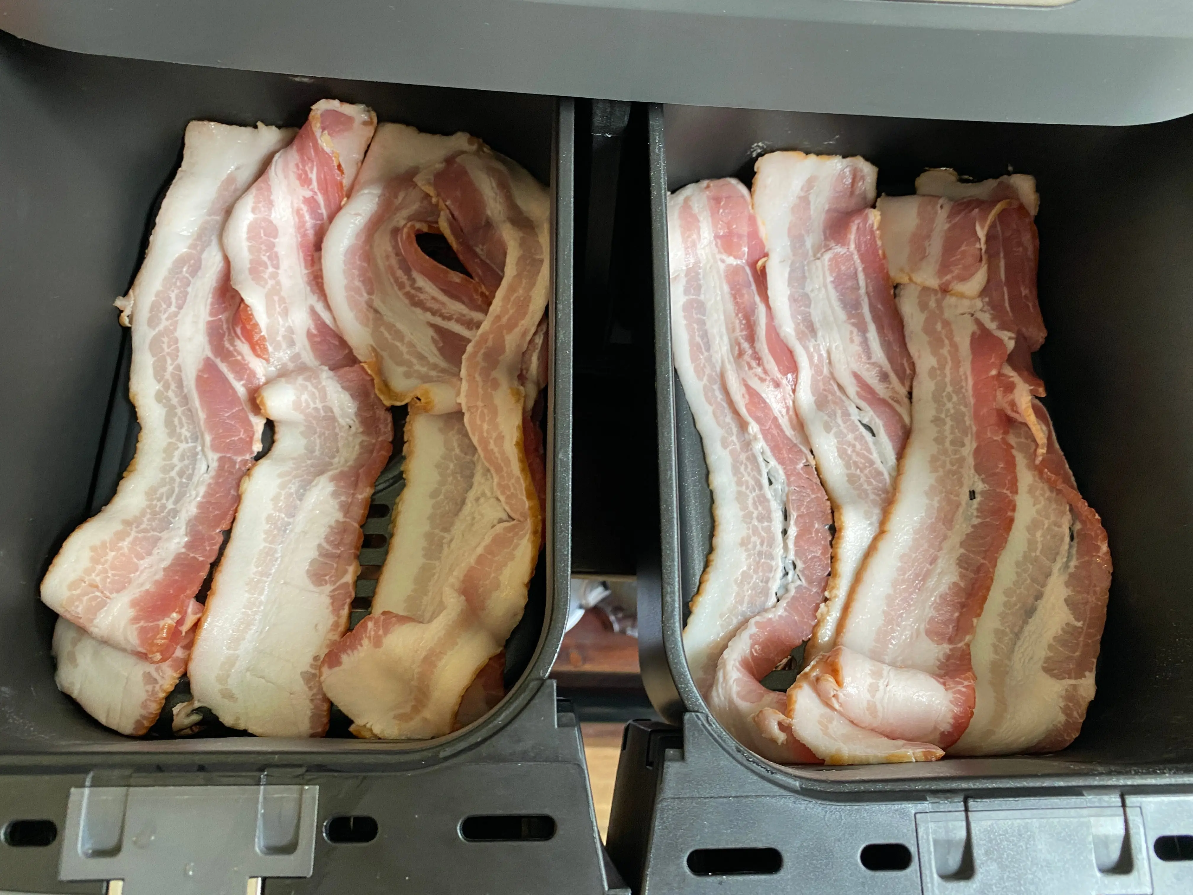 bacon lined up in air fryer baskets