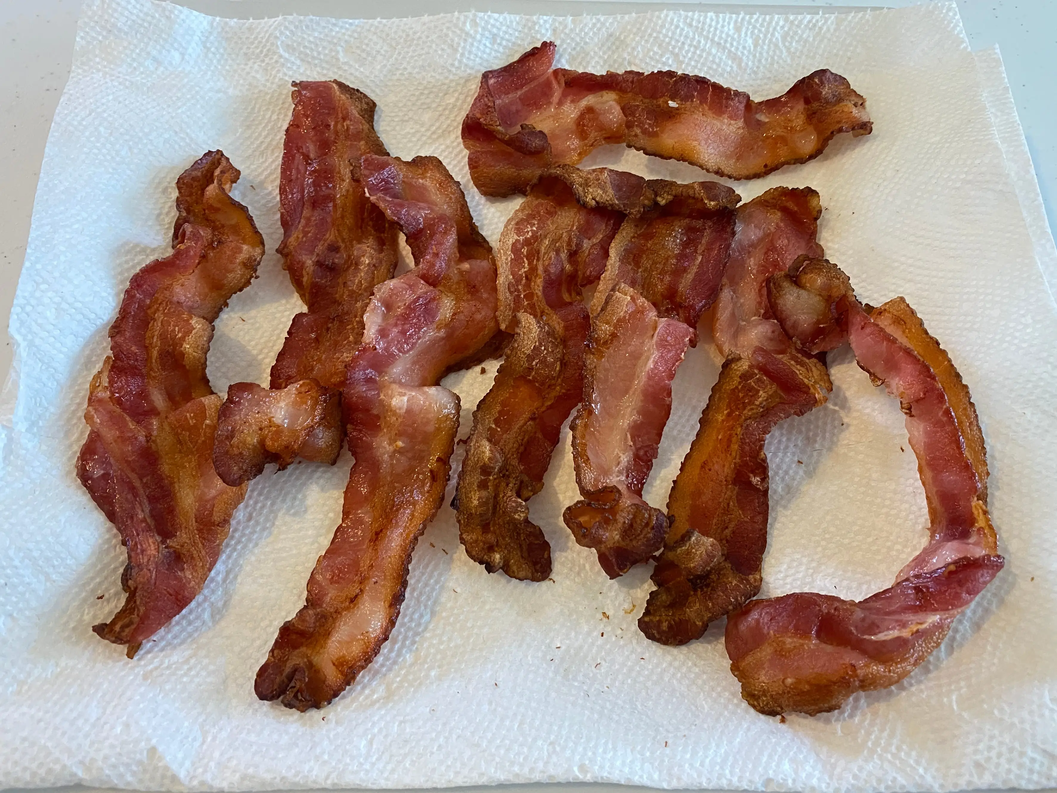 cooked bacon on plate with paper towel