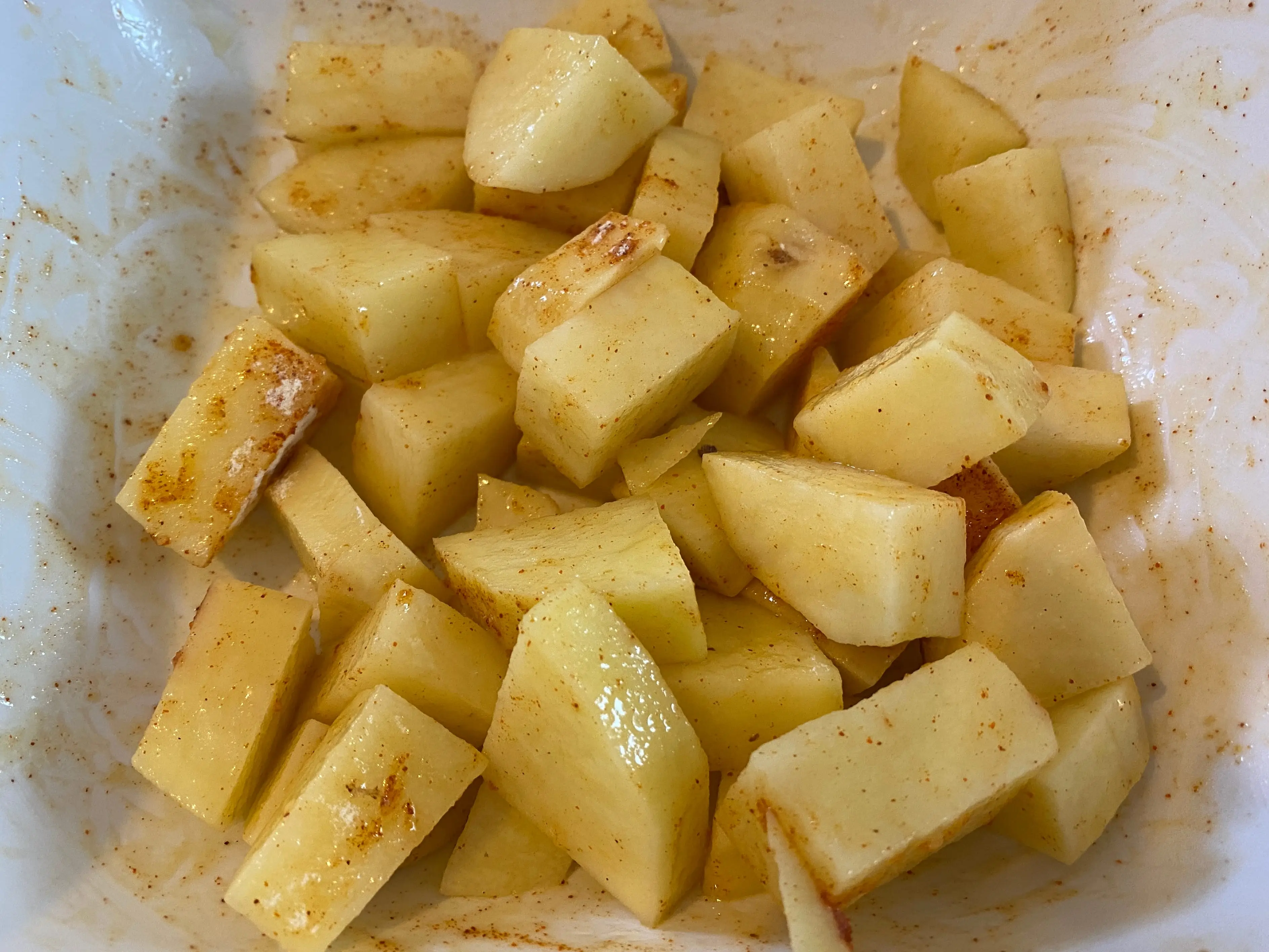 chopped and seasoned potato chunks on paper