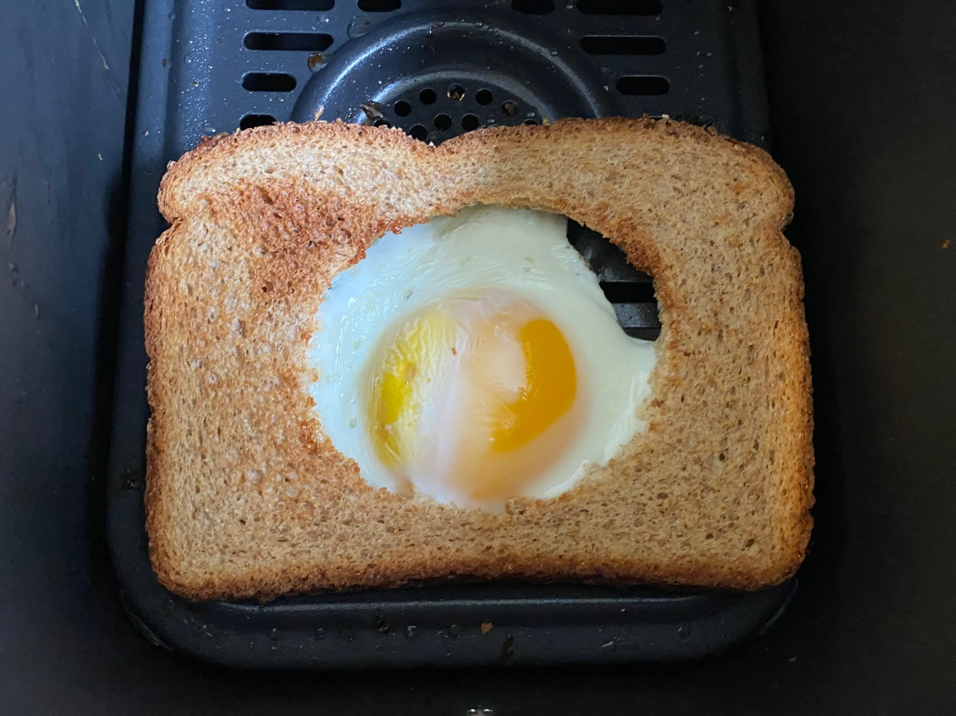 cooked egg in a hole in air fryer basket