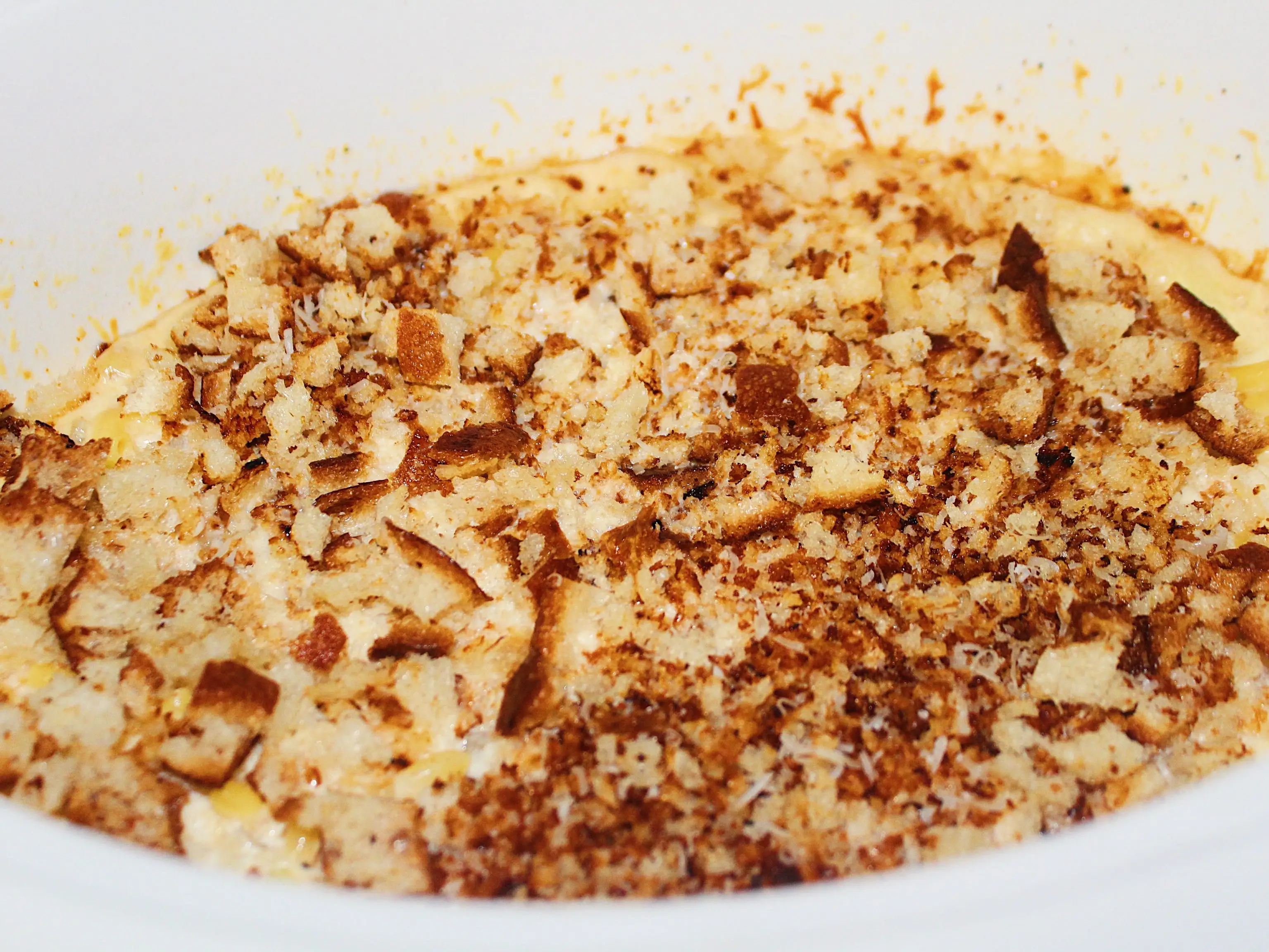 cooked mac and cheese in slow cooker topped with breadcrumbs