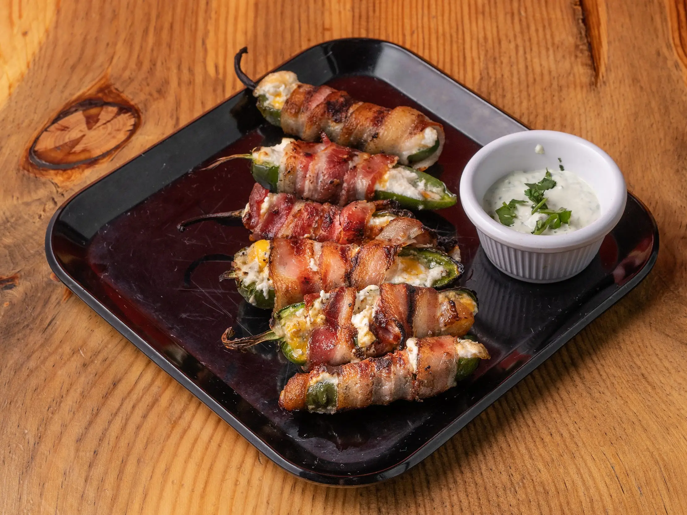 A plate of jalapeño poppers wrapped in bacon.