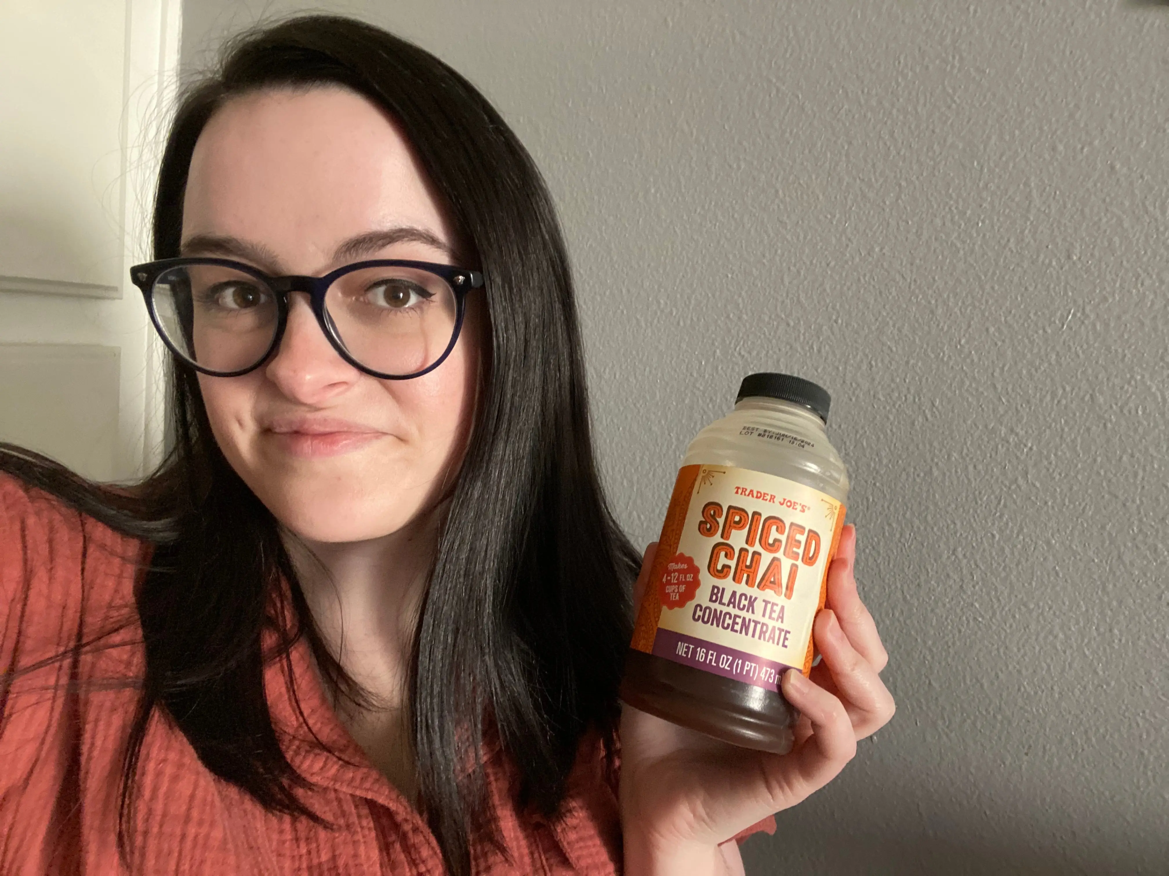 Author holding Trader Joe's container of chai concentrate.