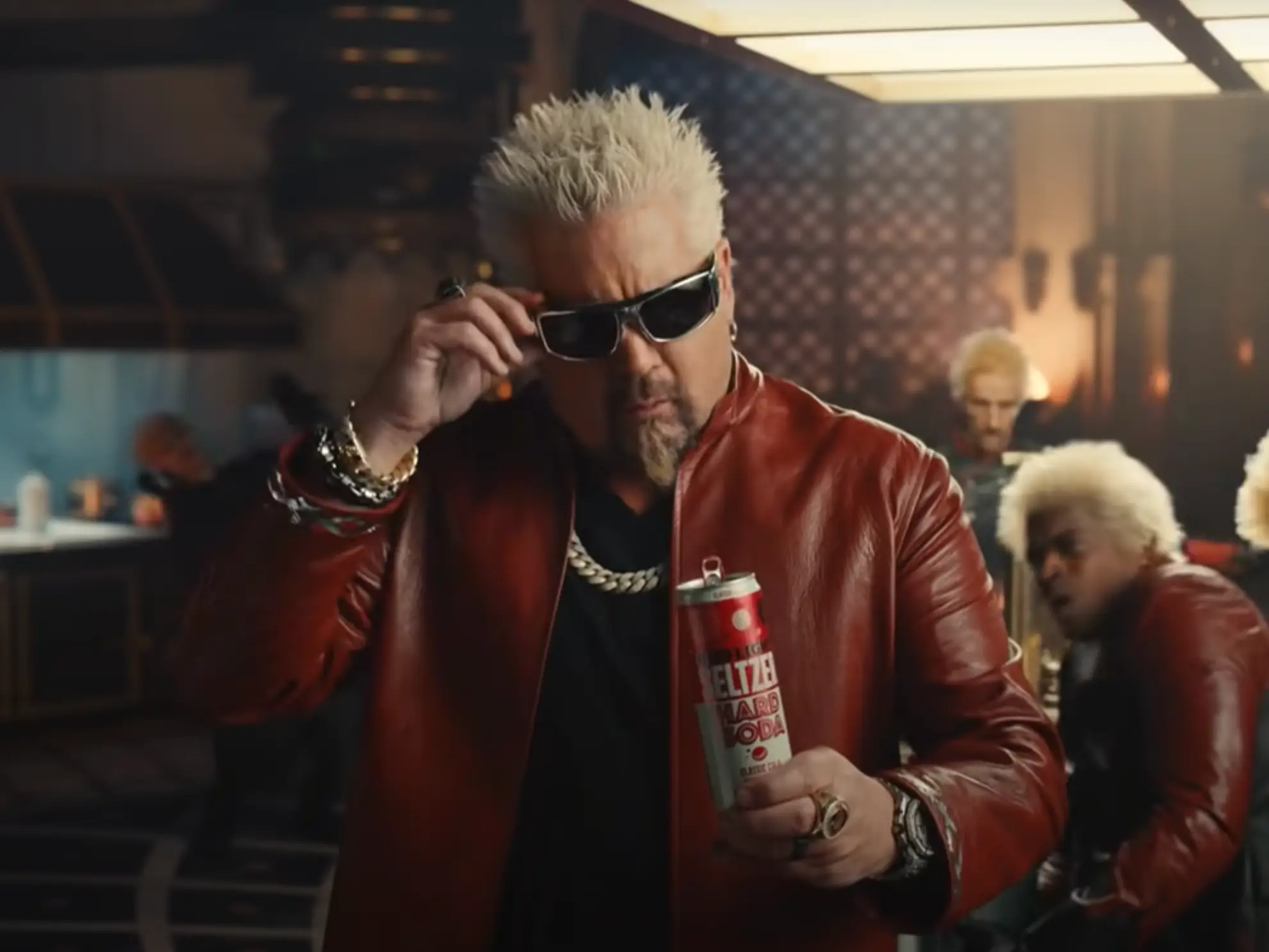 Guy Fieri is getting ready to take off his sunglasses to look at the Bud Light Seltzer Hard Soda in his hand.