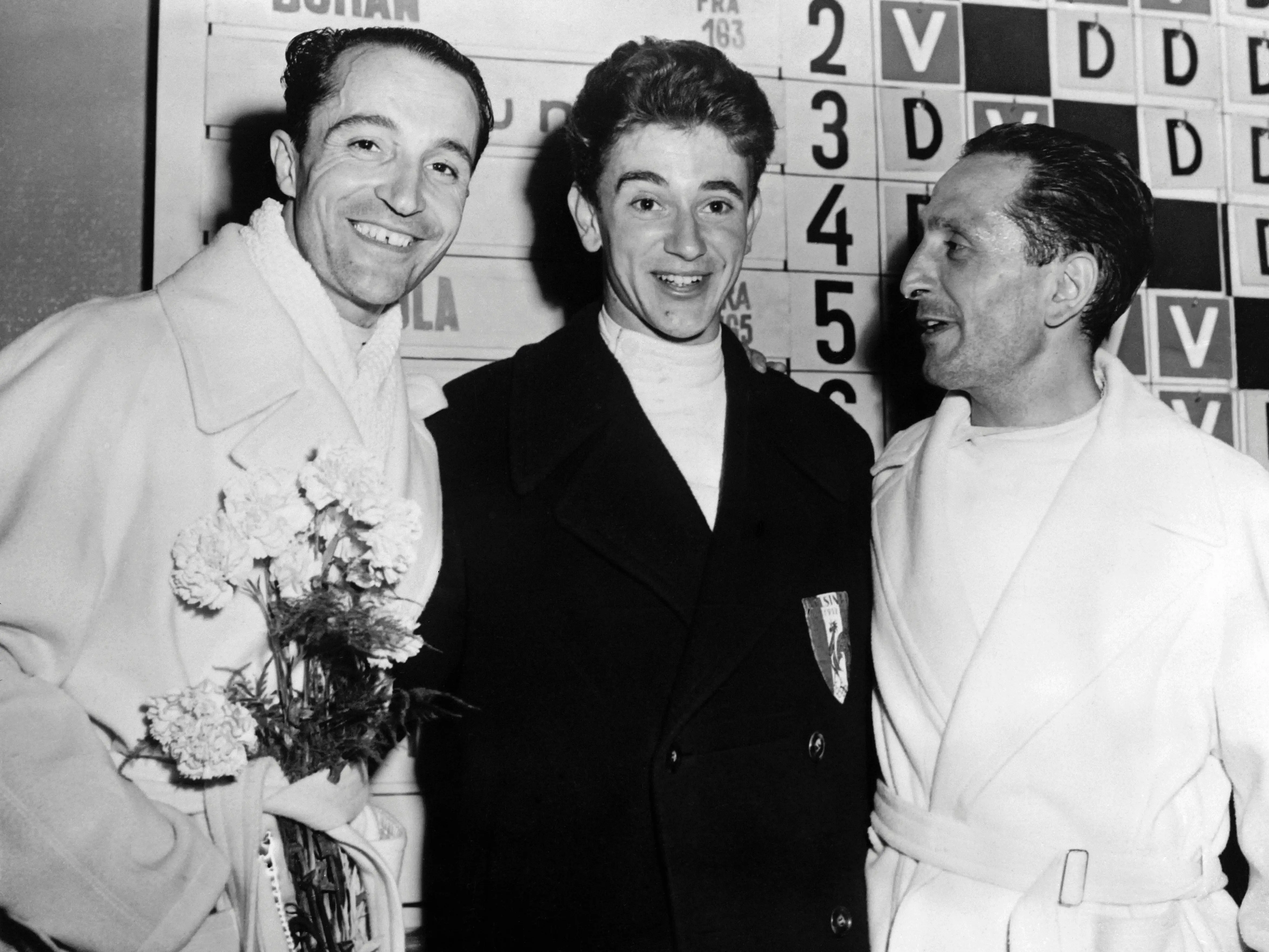 Edoardo Mangiarotti (left) smiled and posed next to fellow Olympic fencers, Christian D'Oriola (center) and Manlio Di Rosa (right). Mangiarotti wore a robe with flowers tucked into the belt.