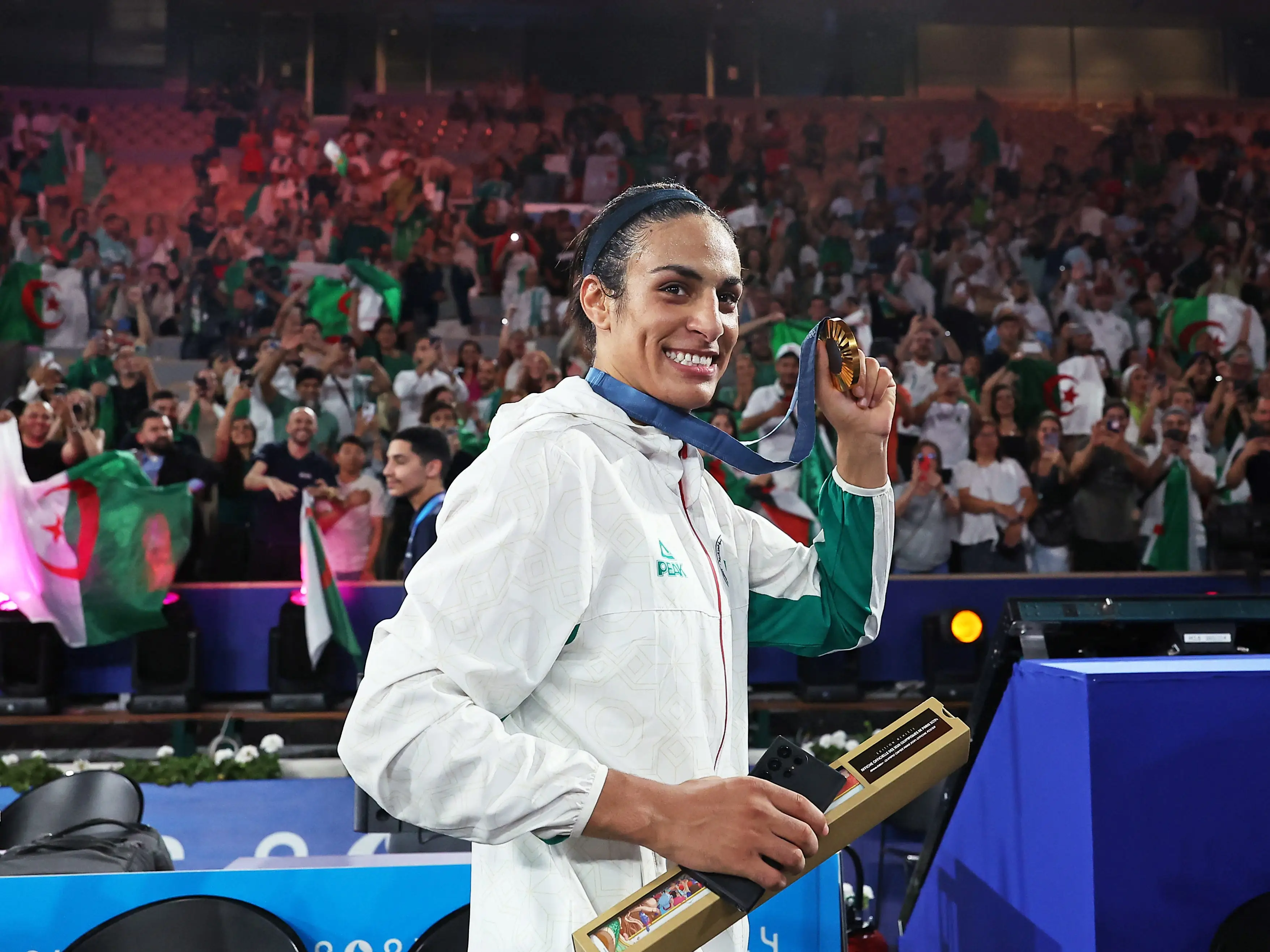 Imane Khelif of Algeria smiled and held up her gold medal to the crowd after winning the women's boxing 66kg event.