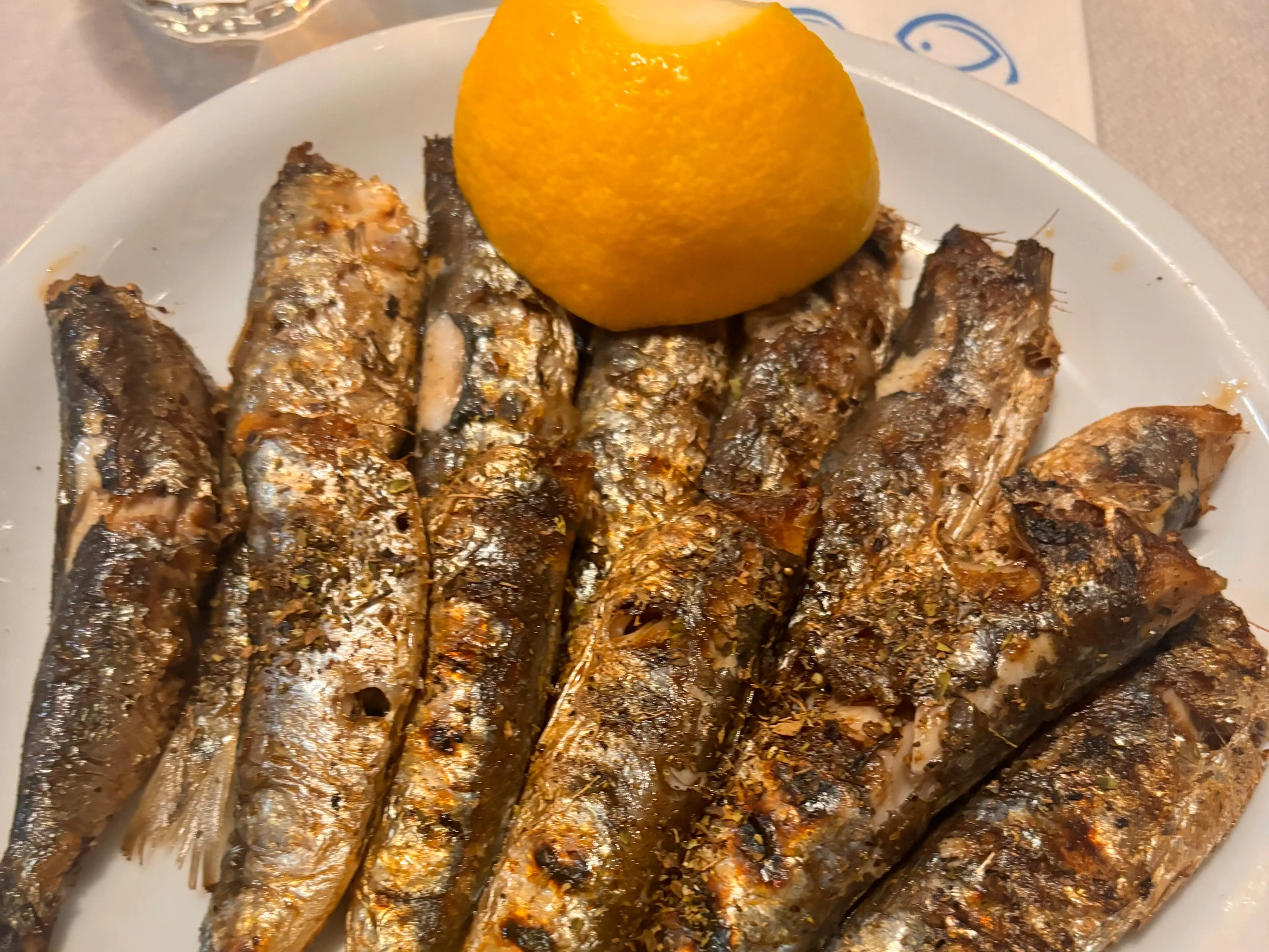 A pate of grilled sardines with two lemon halves.