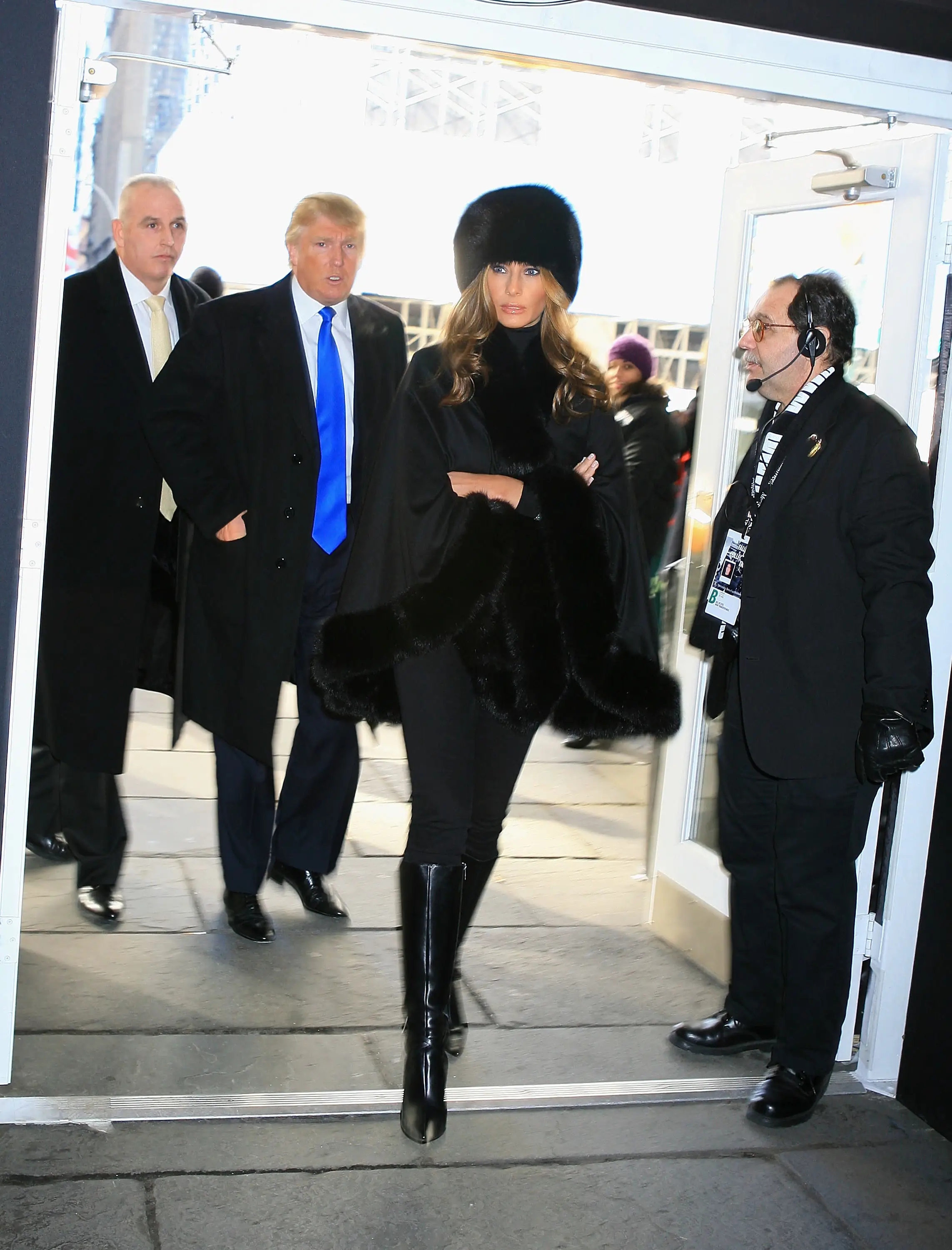 Donald and Melania Trump  walk through a door.