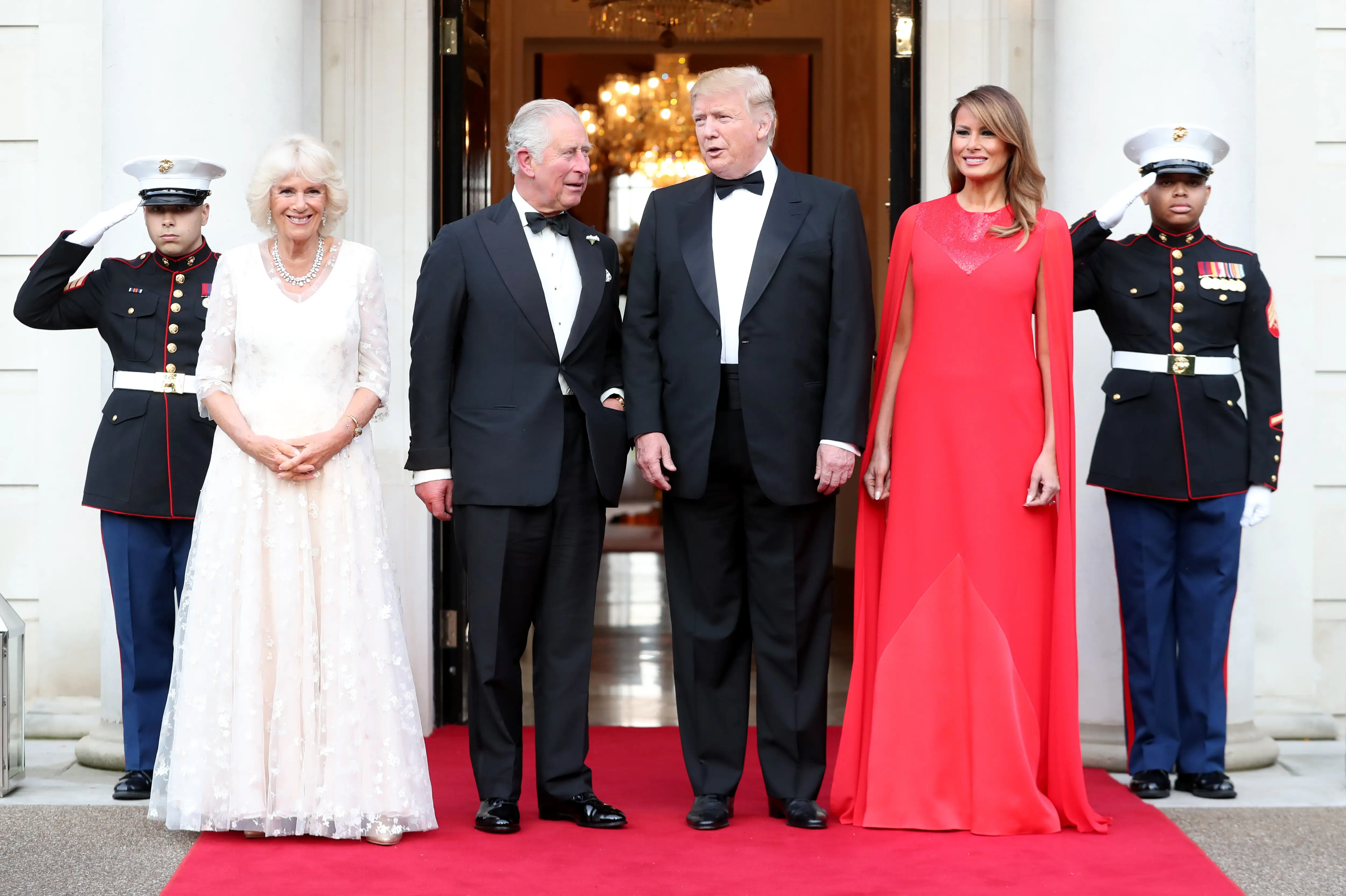Prince Charles and Camilla Parker-Bowles stand with Donald and Melania Trump at the entryway of a home.