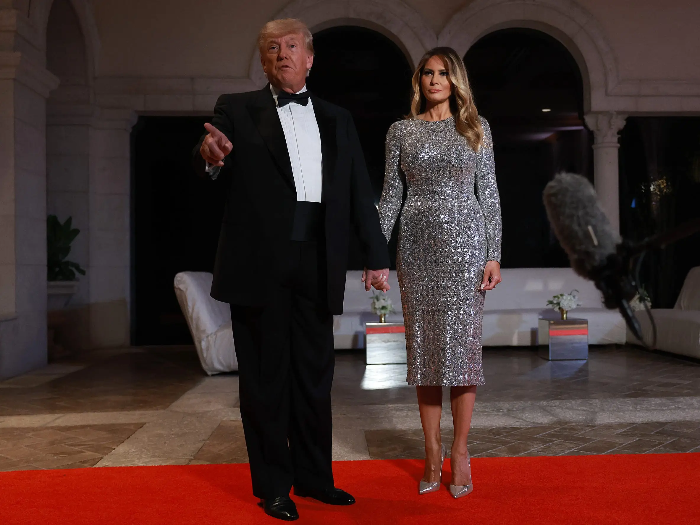 Donald and Melania Trump stand in a foyer.