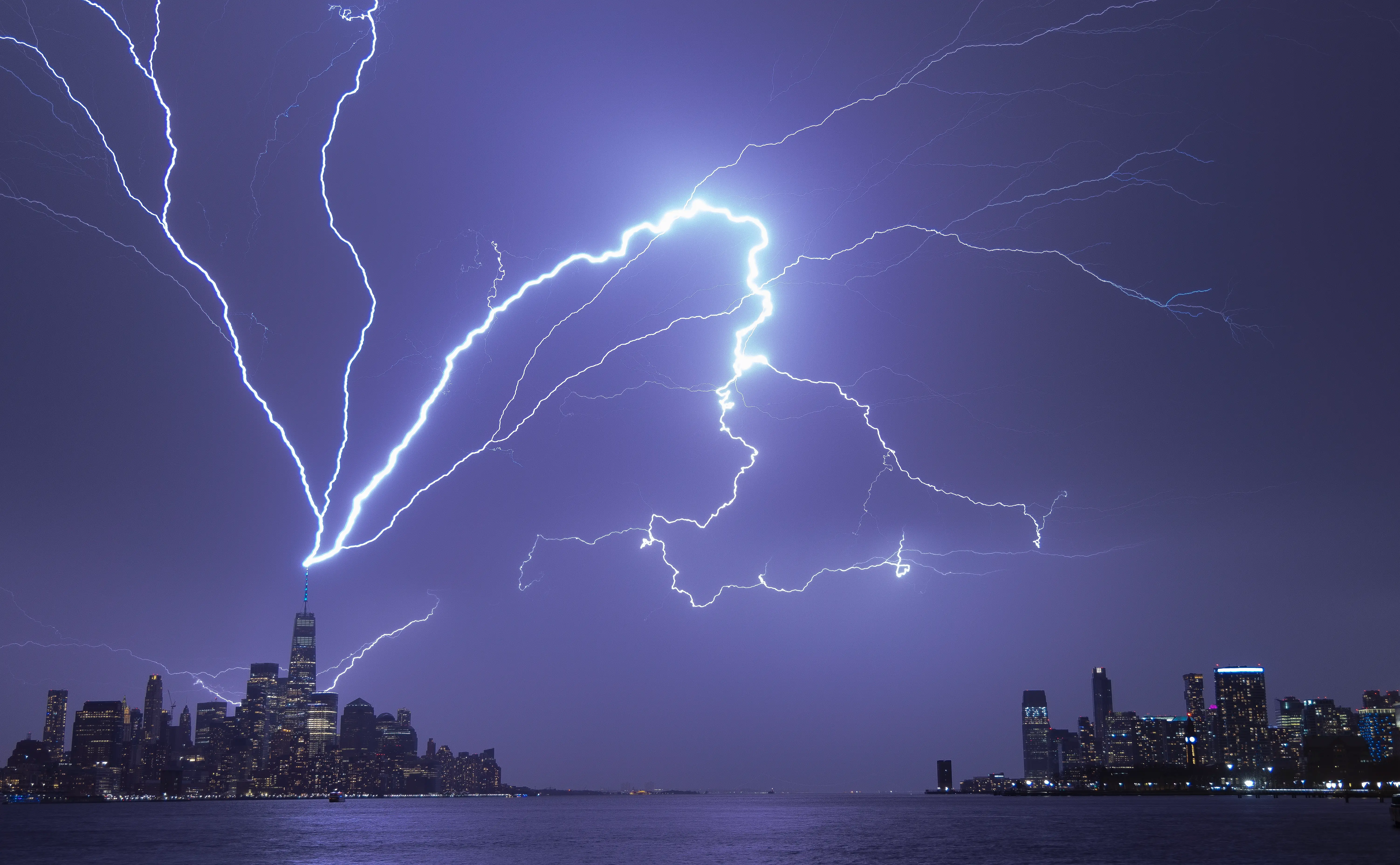 Lightning bolts strike One World Trade Center in New York City as it fans out over the Hudson River and Jersey City, New Jersey during a thunderstorm on April 1, 2023