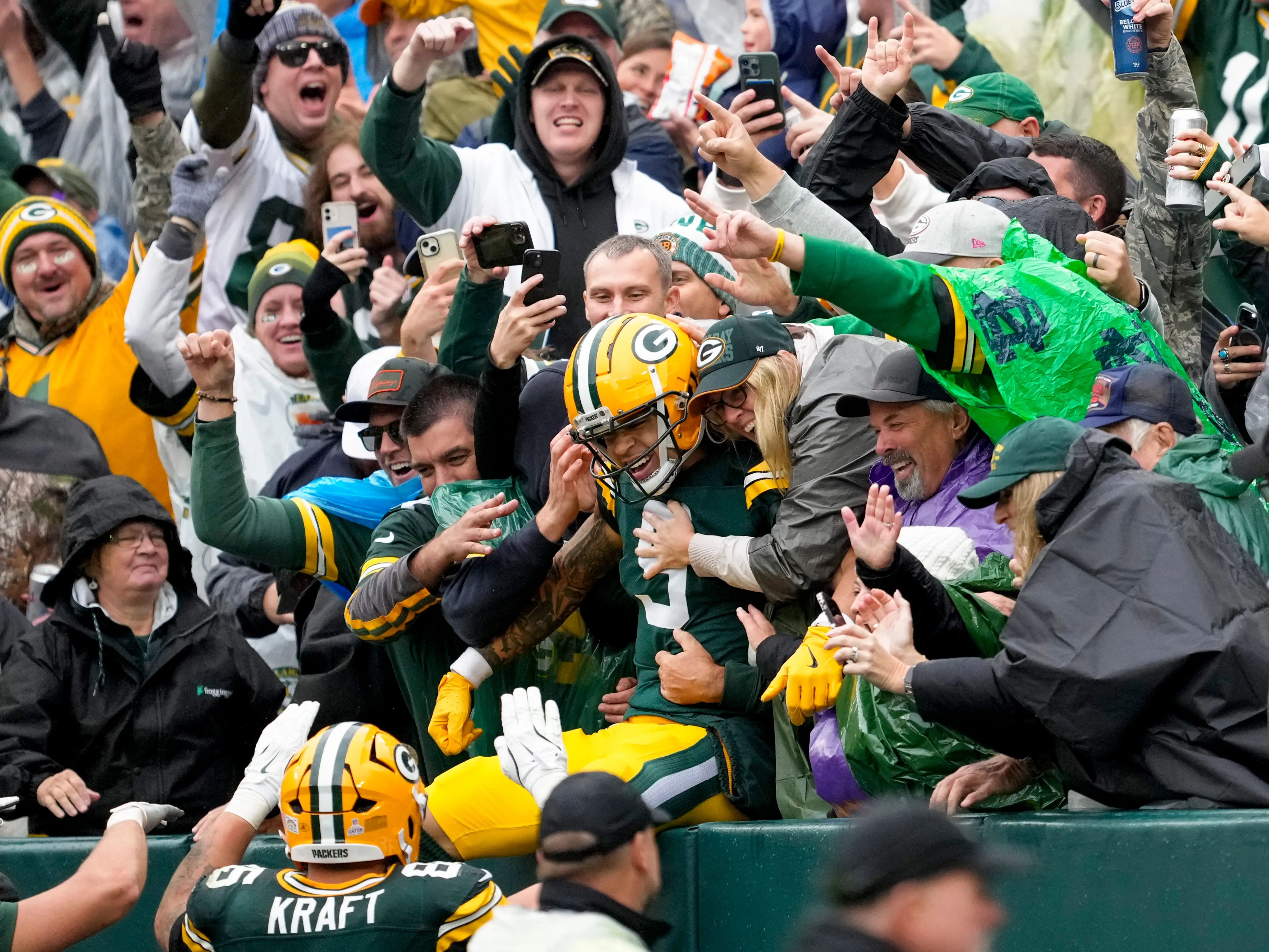 Christian Watson, #9 of the Green Bay Packers, leaped into the stands after scoring a touchdown at Lambeau Field.