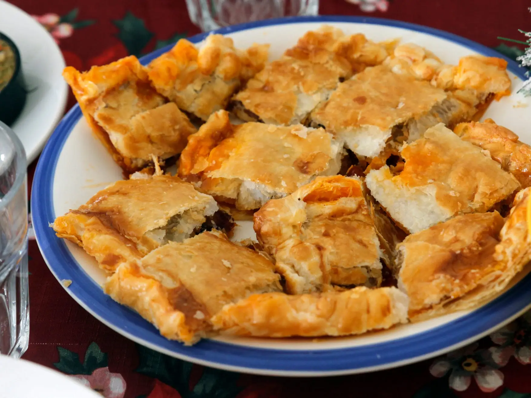 A blue and white plate with an appetizer made with puff pastry  covering the surface