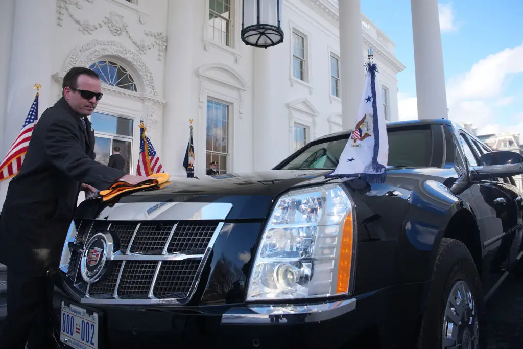 A Secret Service agent shines the presidential limousine.