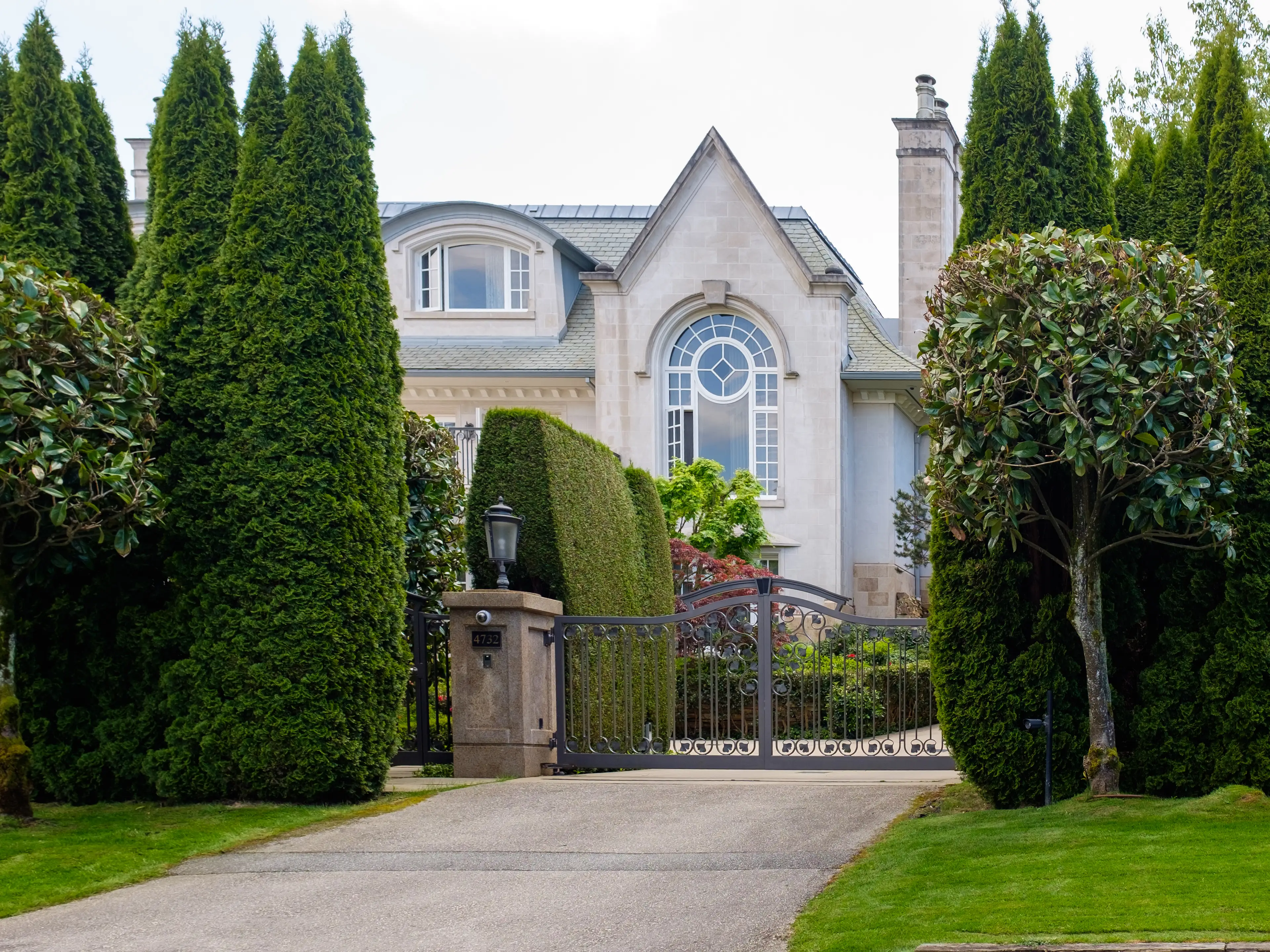A Victorian mansion behind extravagant landscaping