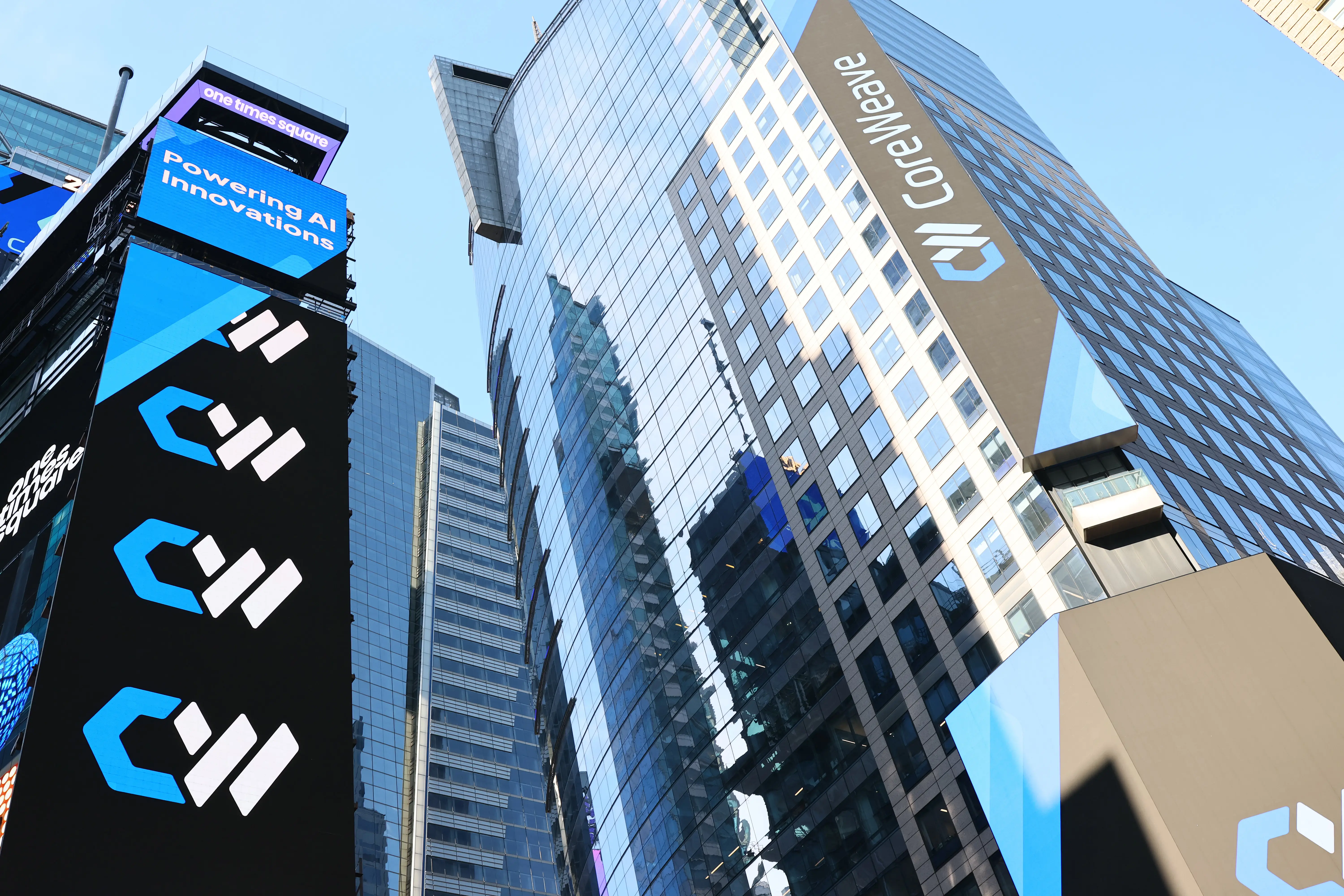 The CoreWeave company name and logo are displayed on digital billboards in Times Square