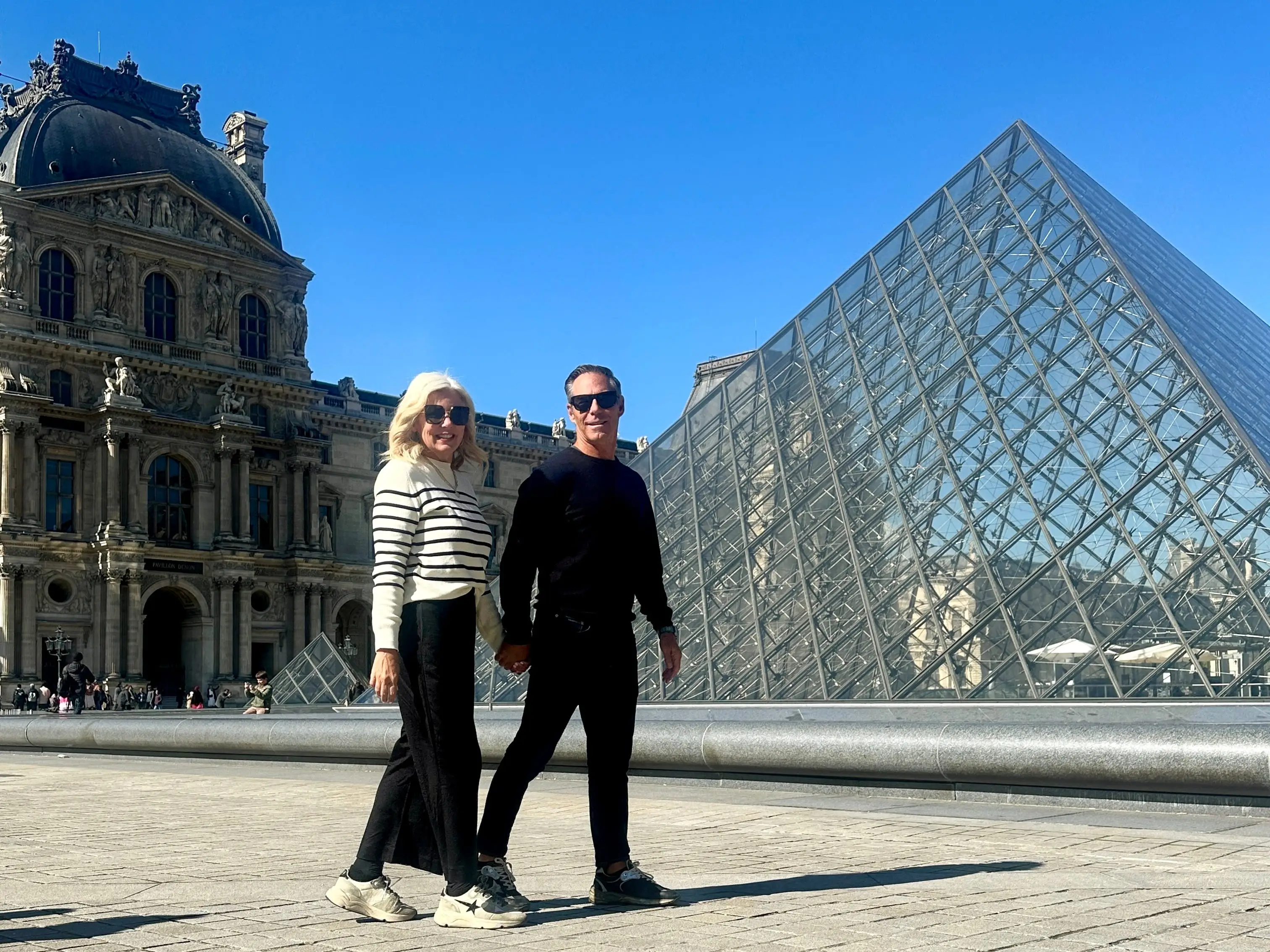 The author and her husband posing outside The Louvre.
