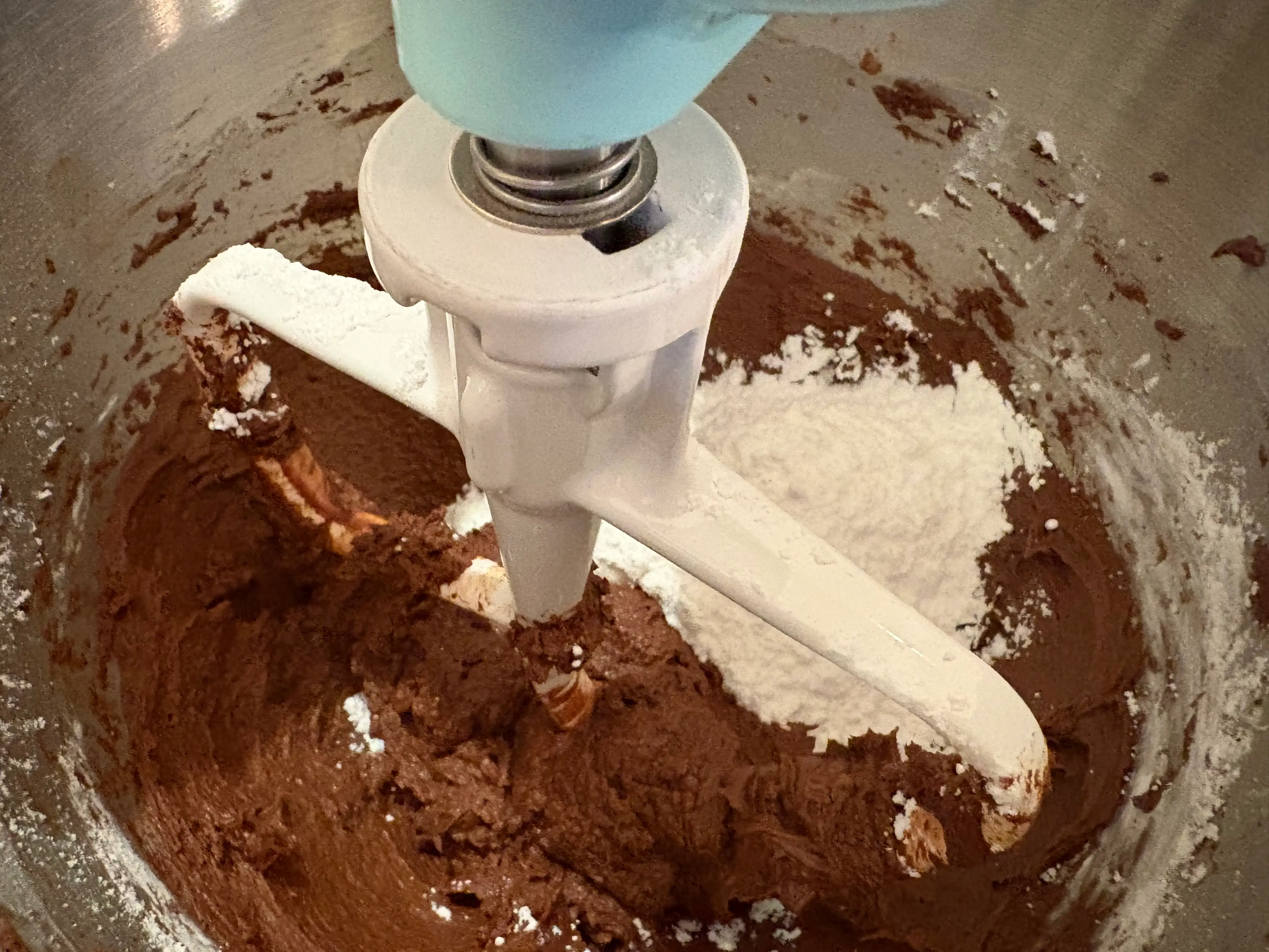 A mixer blending ingredients for the chocolate frosting.
