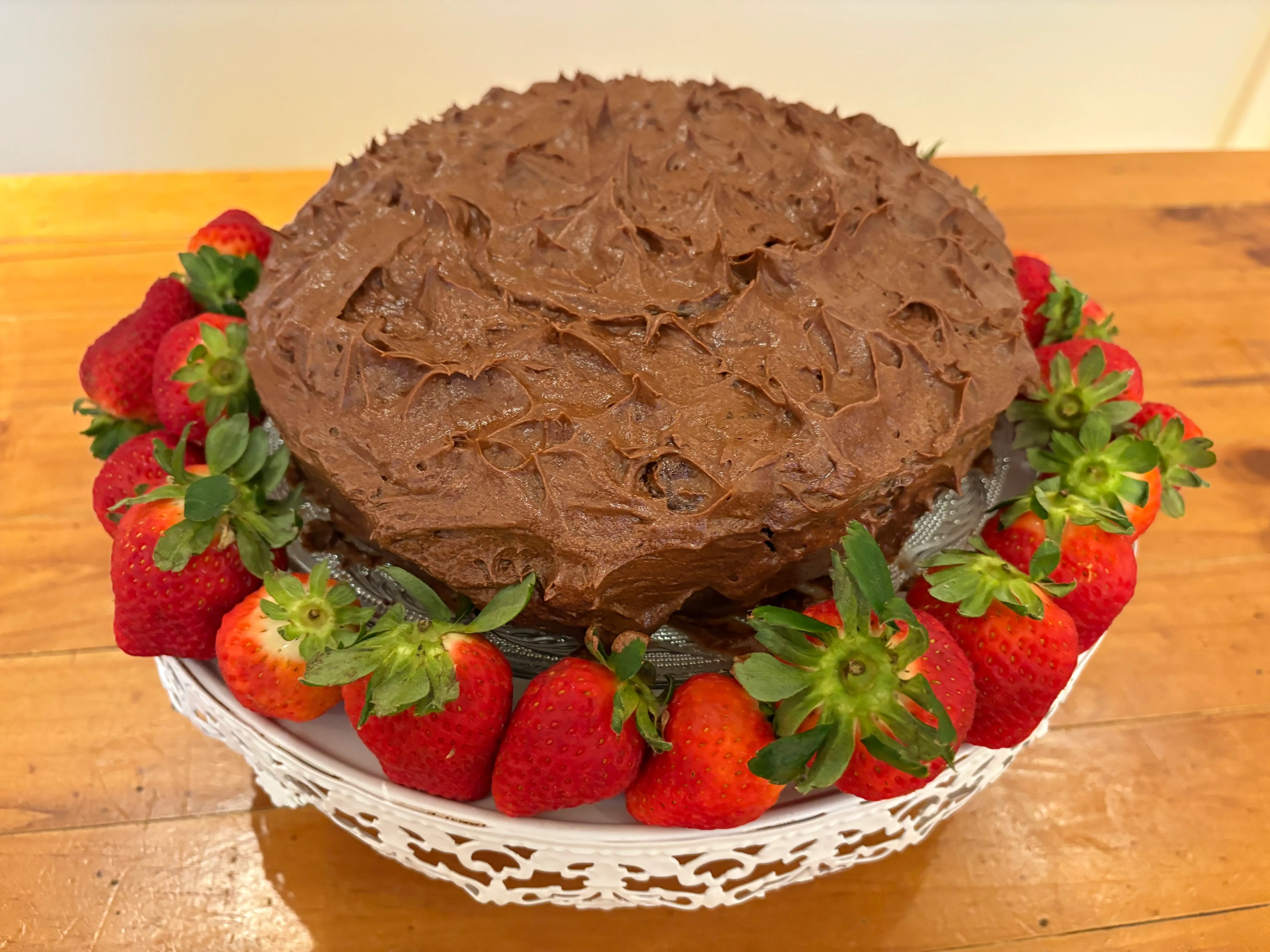 The finished cake on a platter with strawberries.
