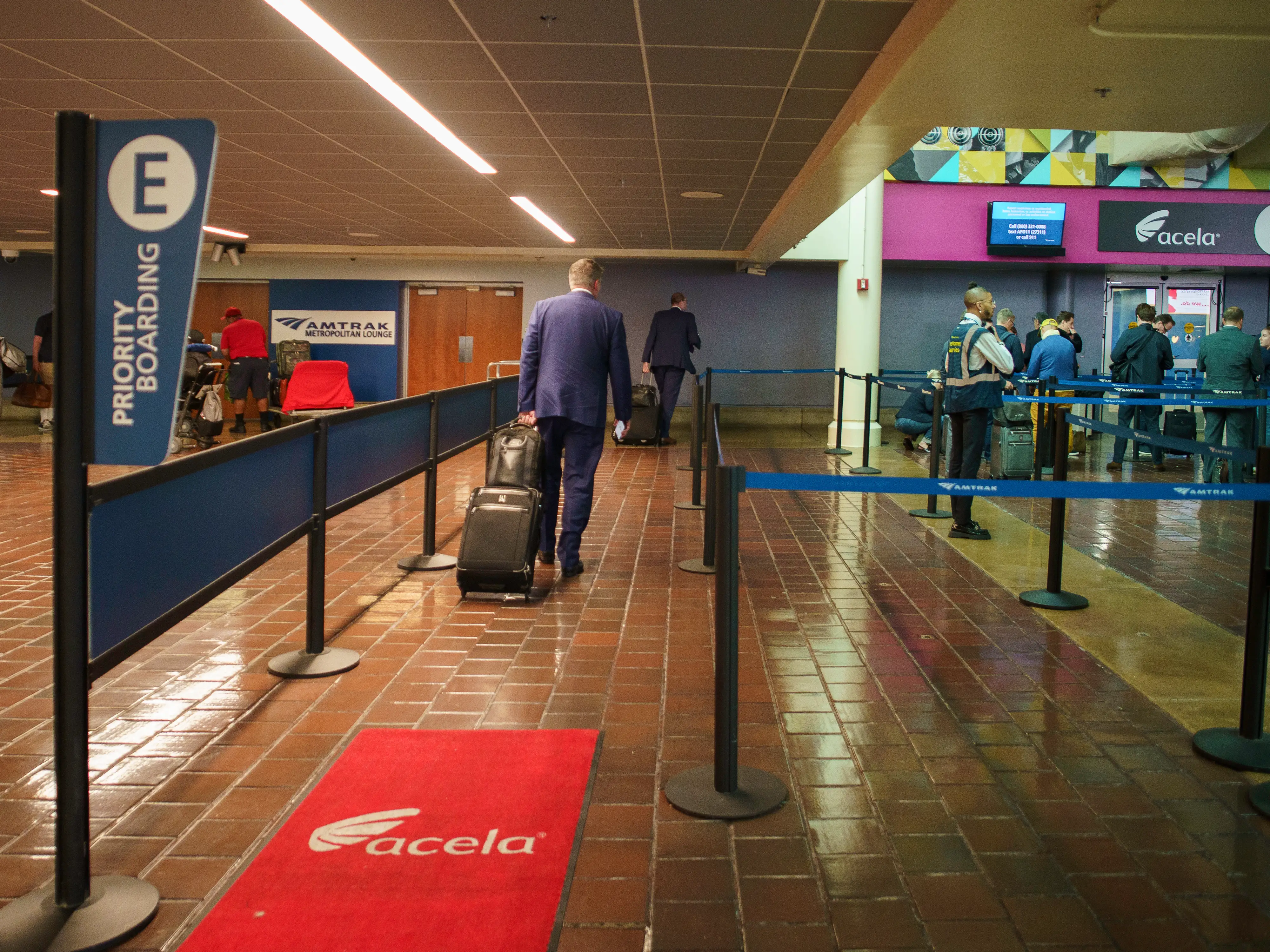Passengers walk into the priority boarding line inside a train station