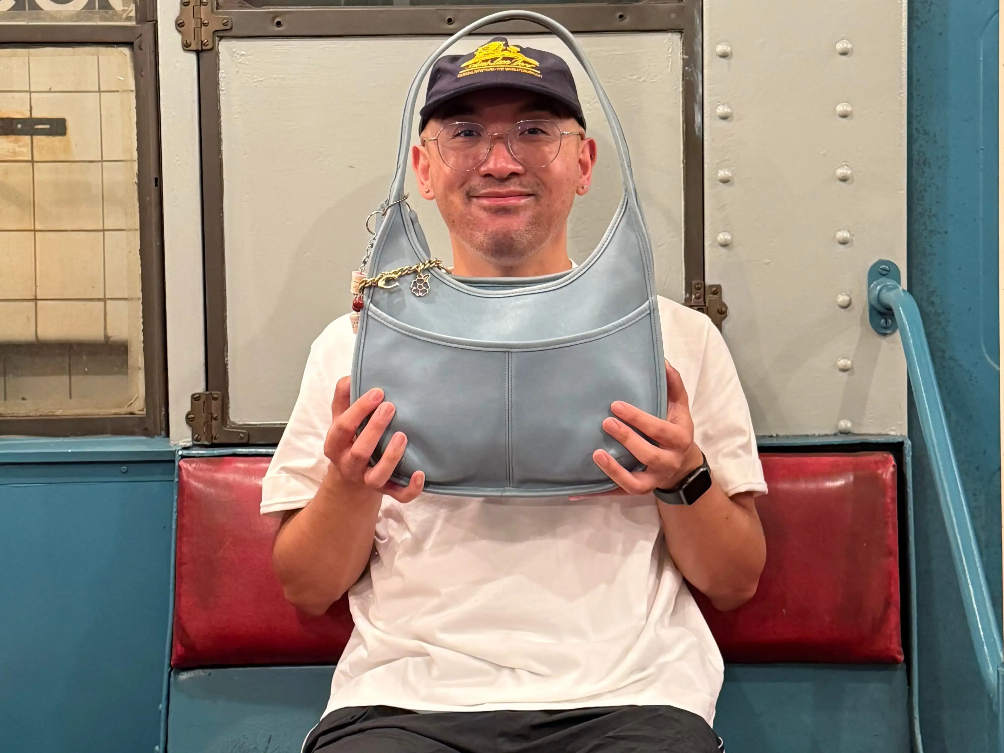 Jonathan Adona holding one of his Coach bags.