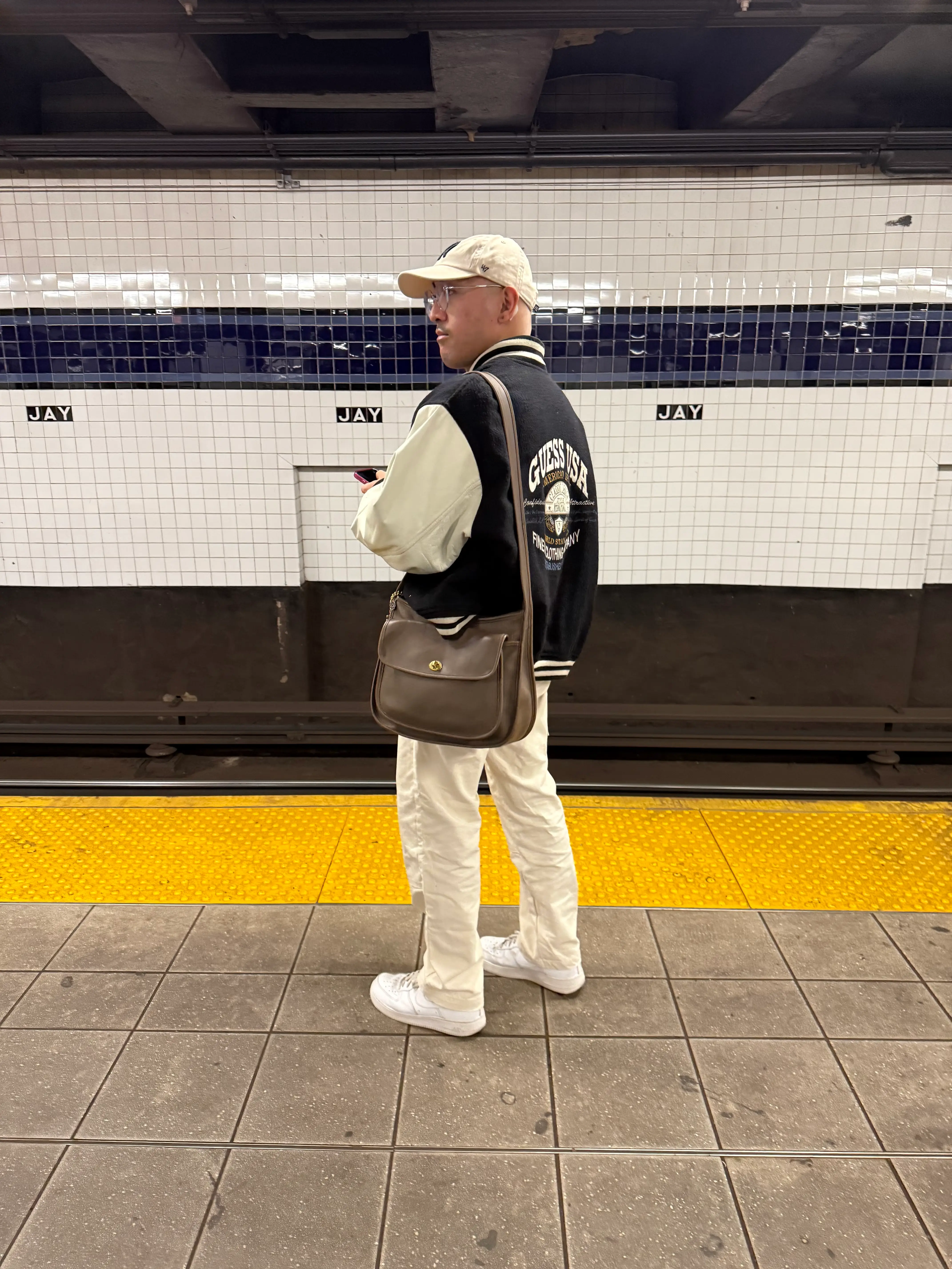Jonathan Adona carries a Coach bag in New York City.