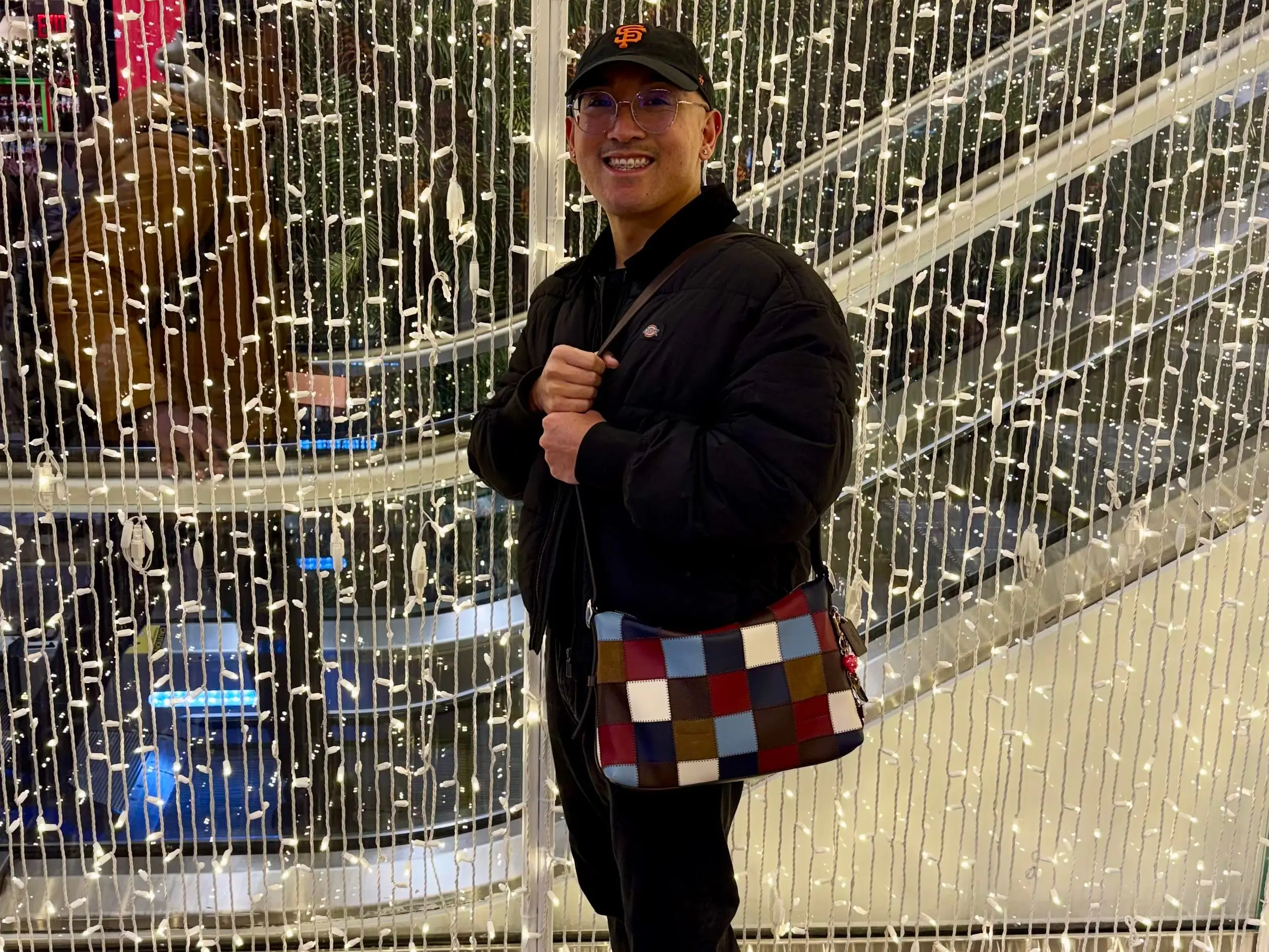 Jonathan Adona carries a modern Coach purse.