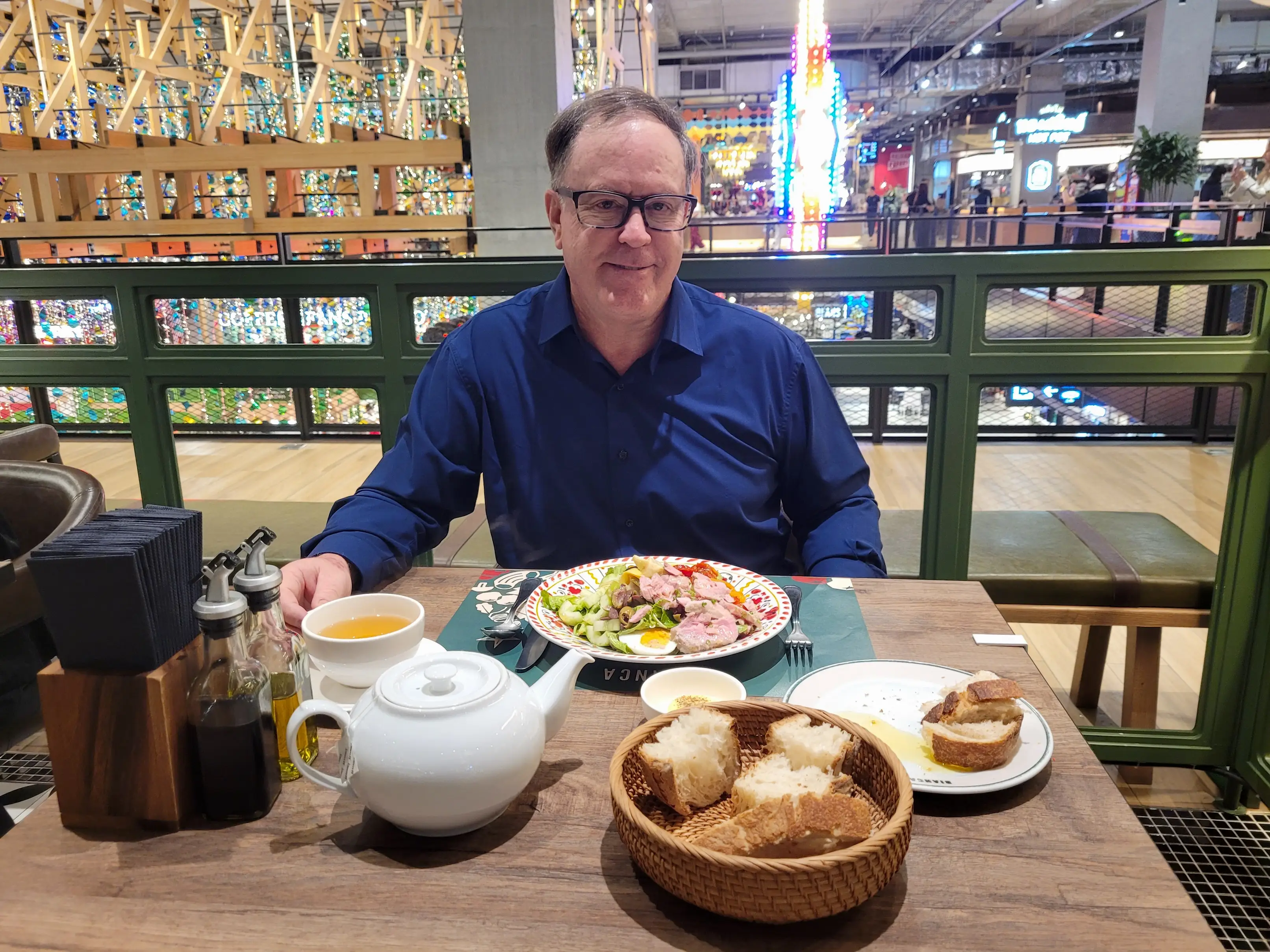 A man dressed in blue at an Italian restaurant in Bangkok.