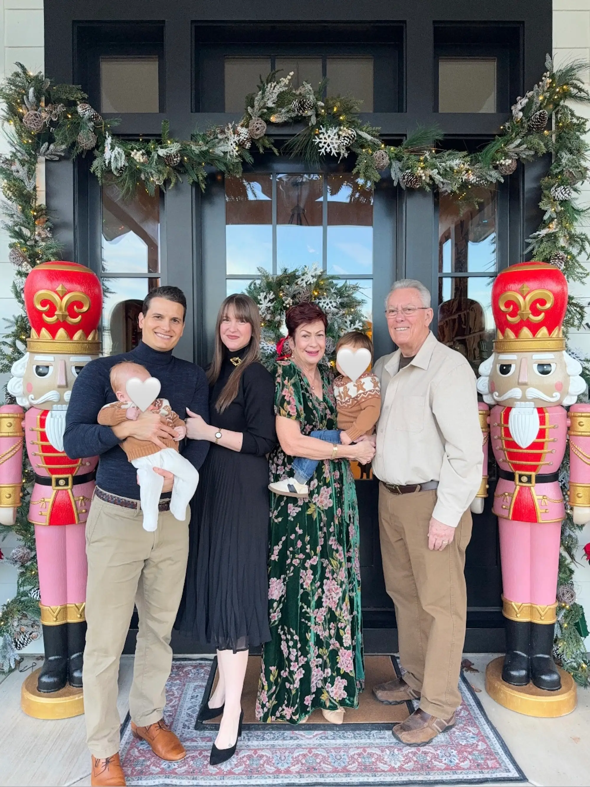 A family of six stands in front of a doorway framed by two lifesize nutcrackers.