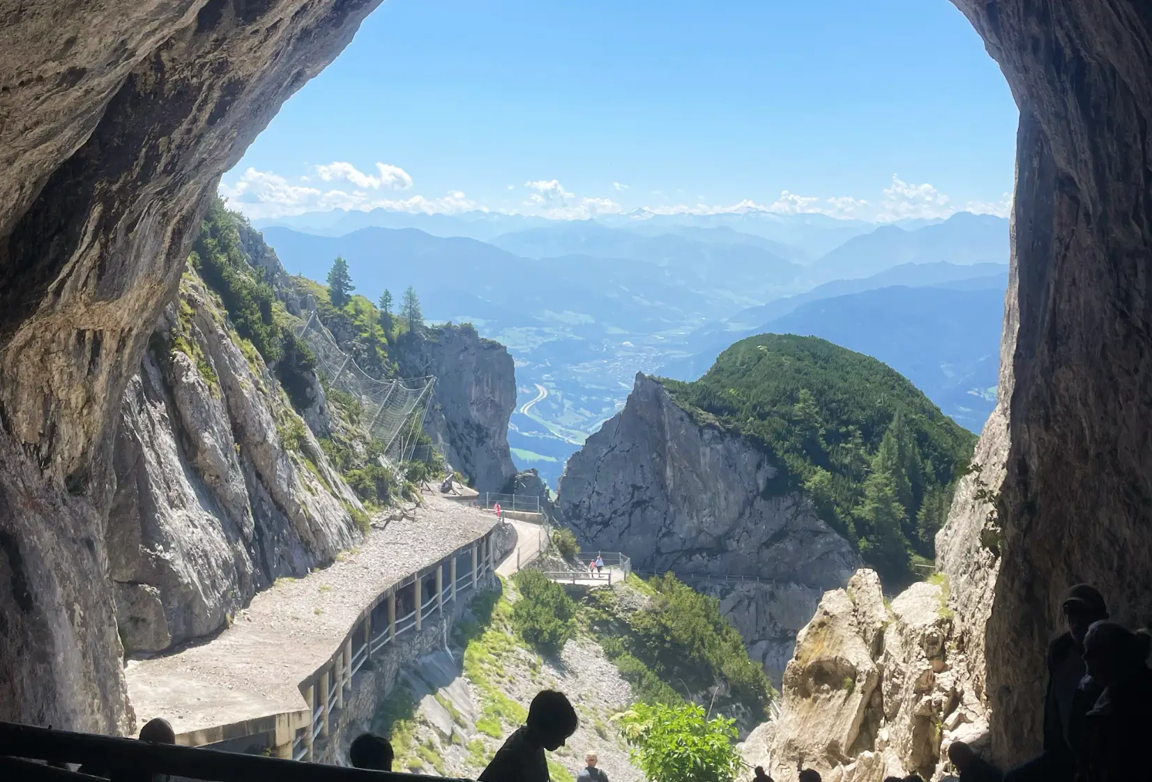 A view from the Eisriesenwelt in Austria, with other tourists and hikers visible.