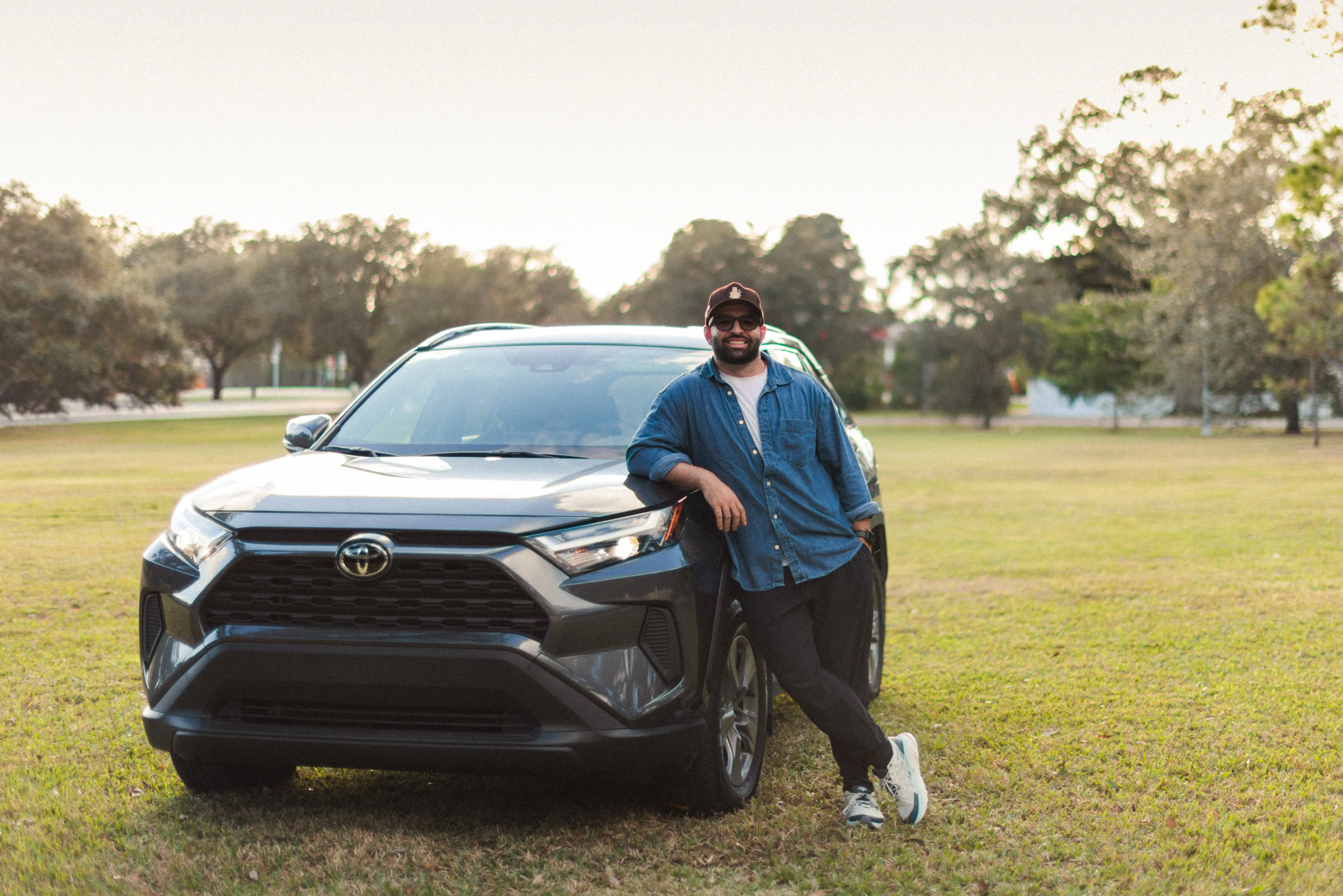 Author Vincent Rives posing with a car in field