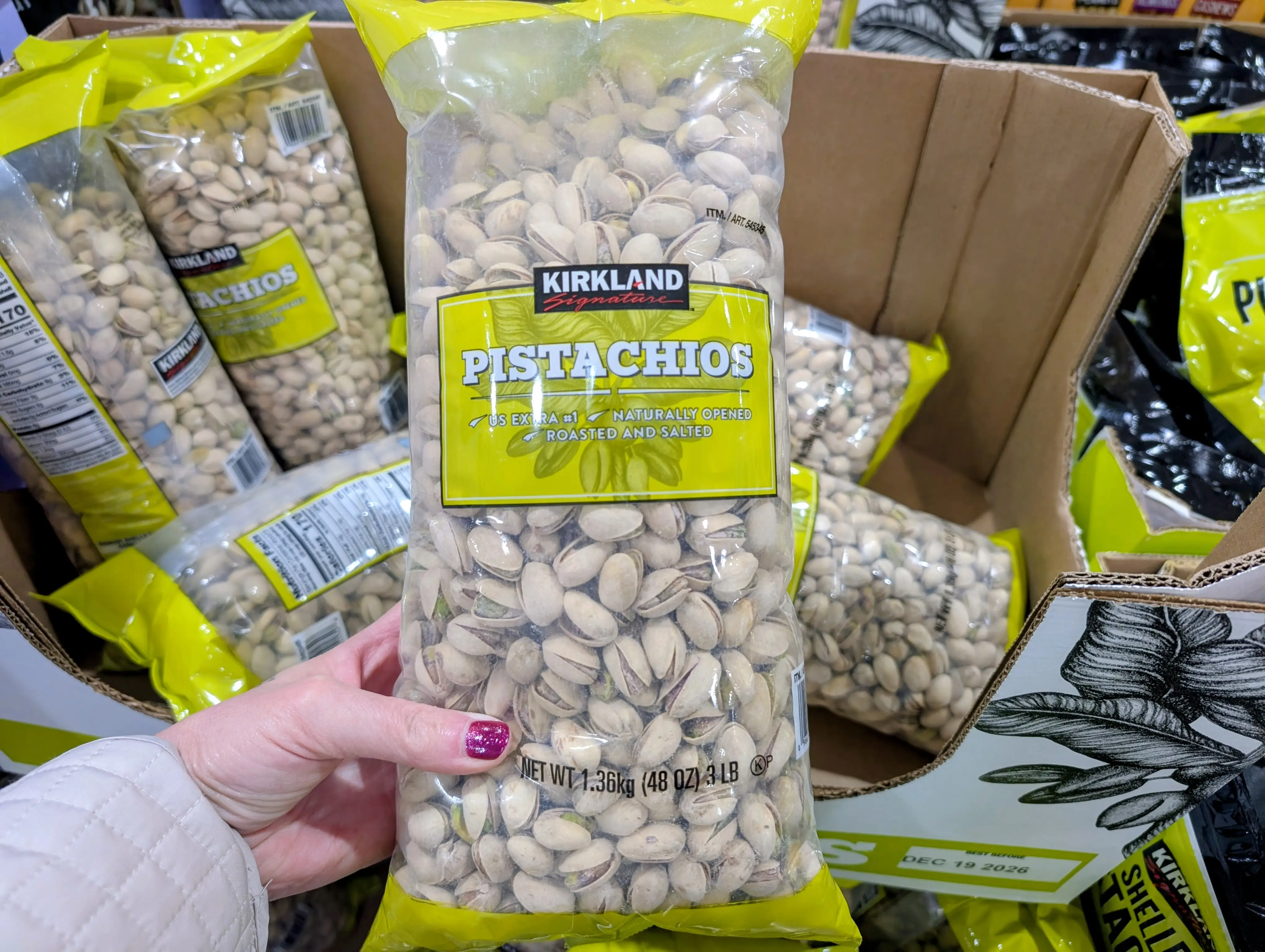 Kirkland Signature pistachios being held by someone at Costco