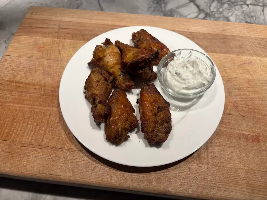 Chicken wings on plate with small bowl of ranch