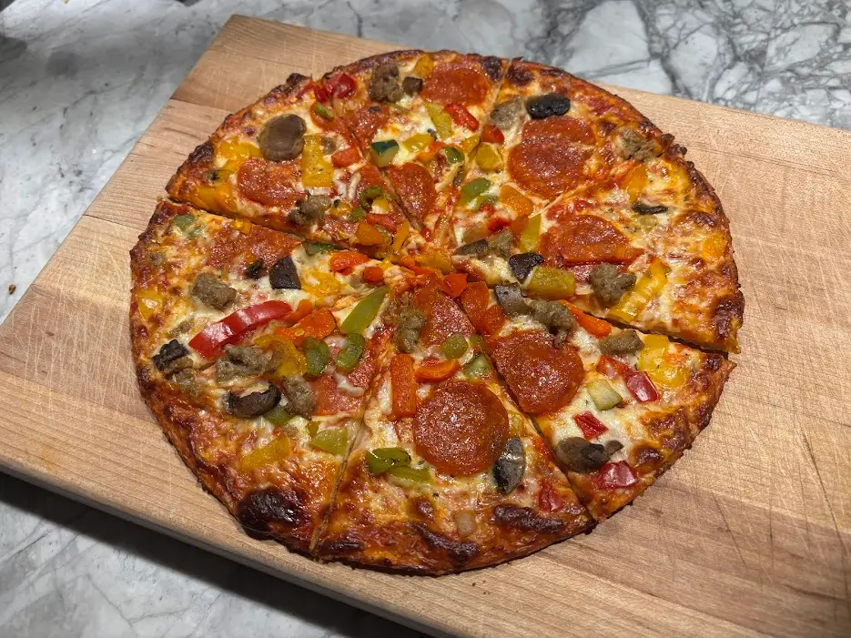 Cauliflower-crust pizza with golden-brown crust, cheese, veggies