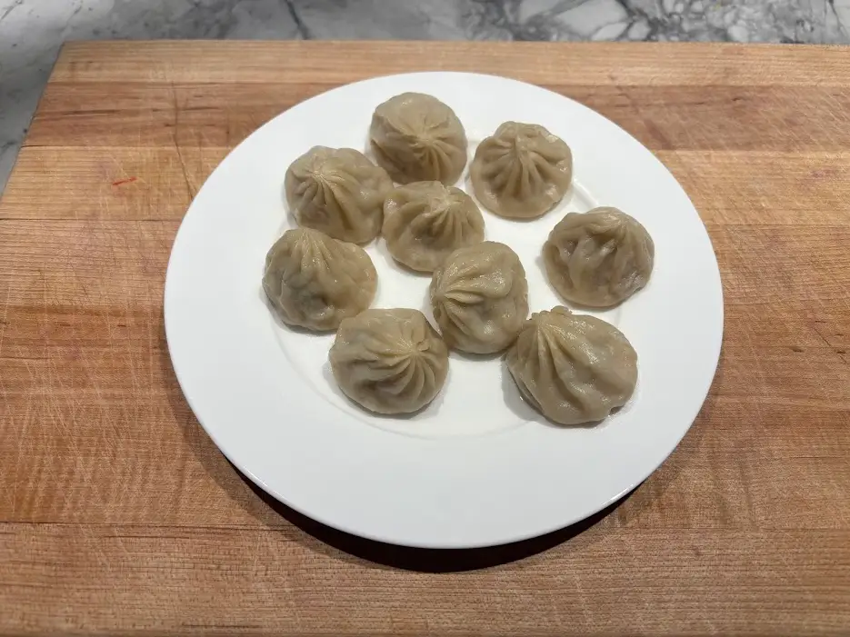 Soup dumplings arranged on white plate